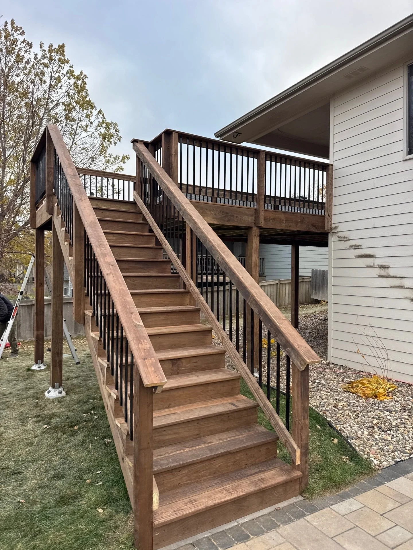 cedartone pressure treated deck with default railing and black metal spindles