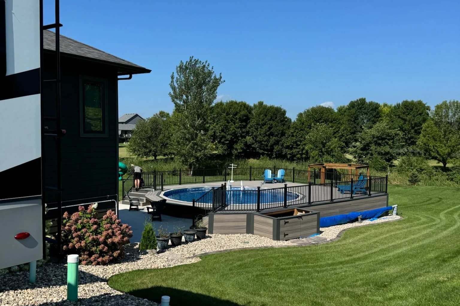 composite pool deck with black metal railing and equipment encosure