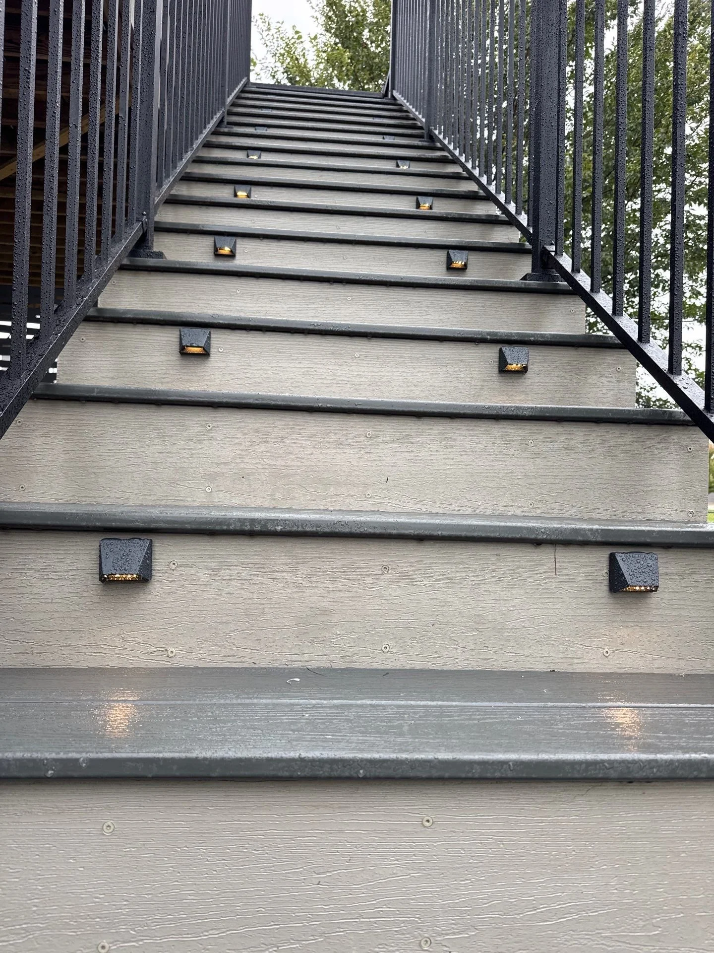 composite deck stairs with integrated lighting and black aluminum railing