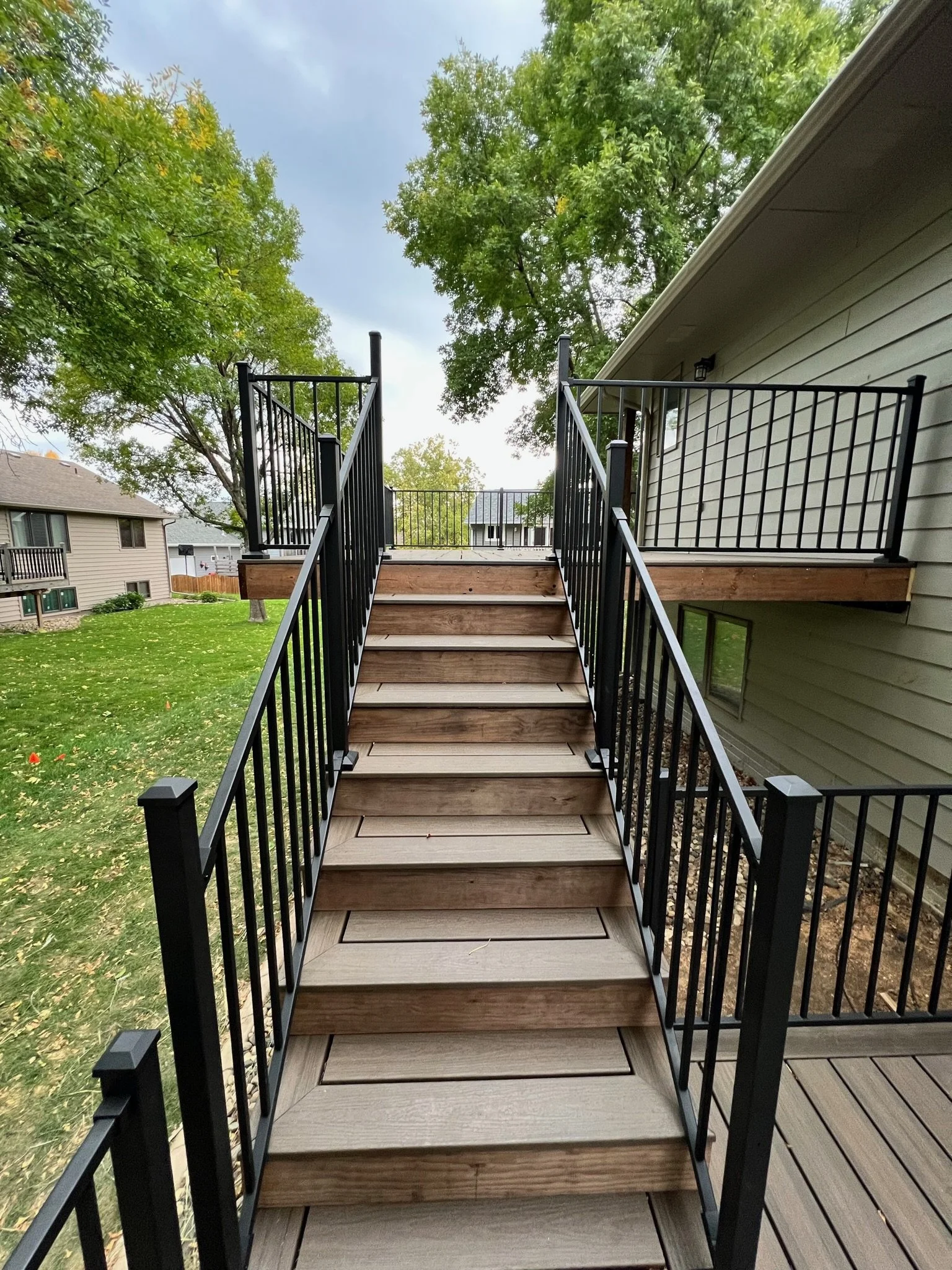 trex composite deck with picture framed stairs and black metal railing