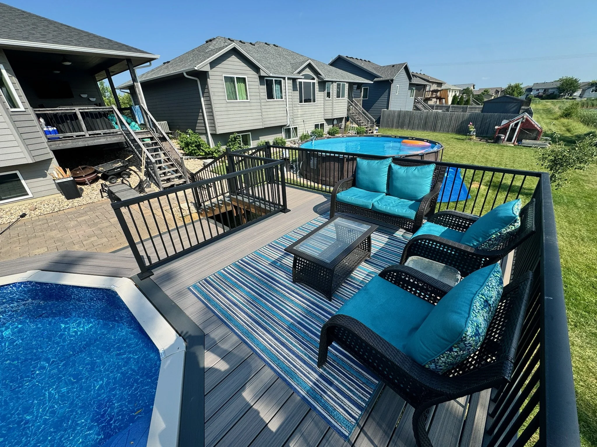 composite pool deck with black aluminum railing and integrated gate
