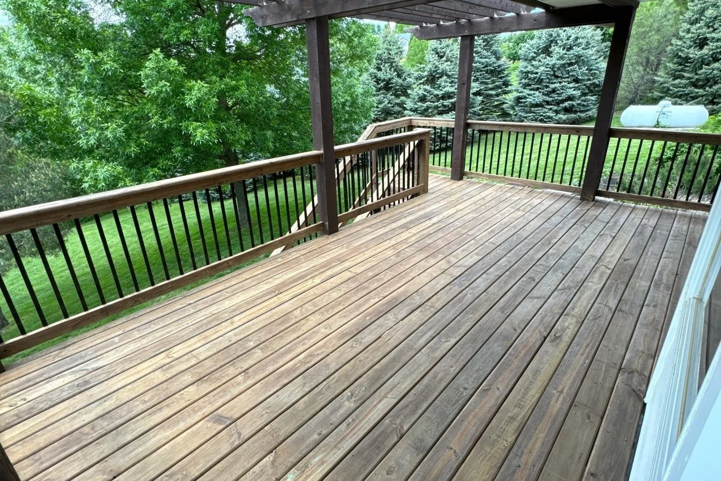 cedartone pressure treated deck boards with default railing and black metal spindles top view