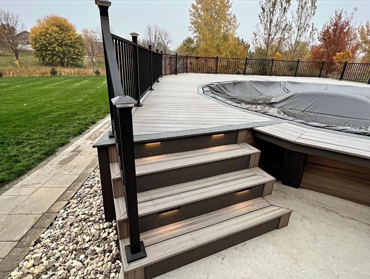 trex composite pool deck with picture framed stairs and black metal railing
