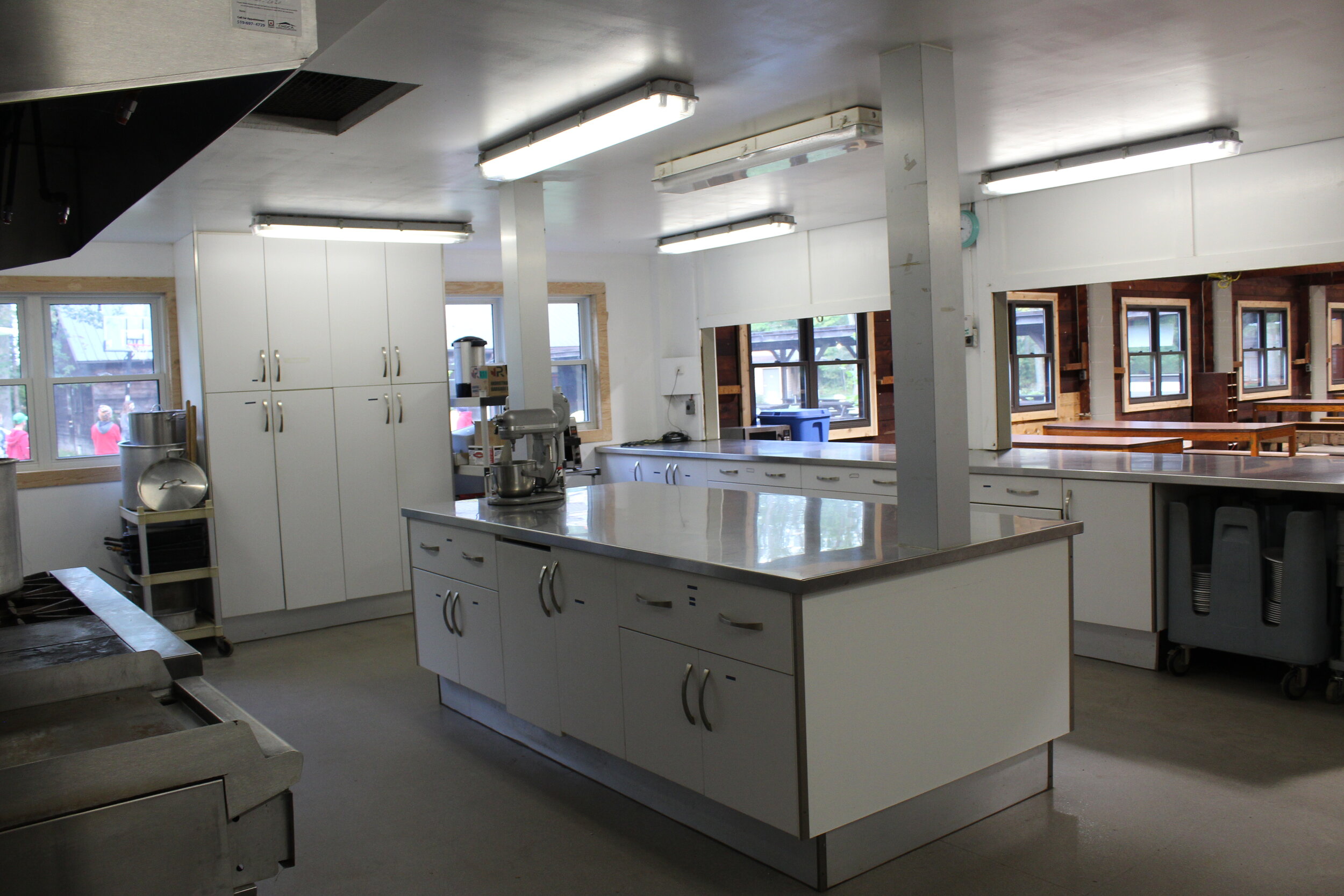 The kitchen's large, bright workspace opens up into the Dining Hall