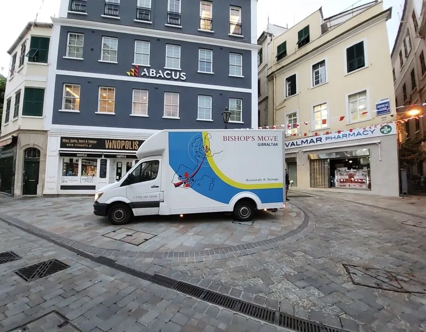 Bishop’s Move vehicles and a removal team using a furniture lift outside an apartment building in Gibraltar