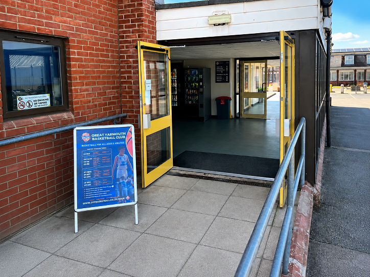 Entrance to East Norfolk Sixth Form College sports hall with Great Yarmouth Basketball Club signage outside.