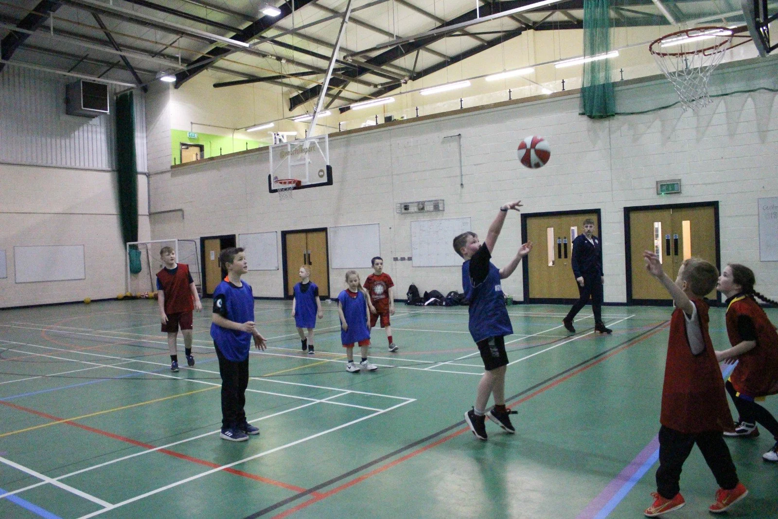 Junior players shooting during a basketball camp.
