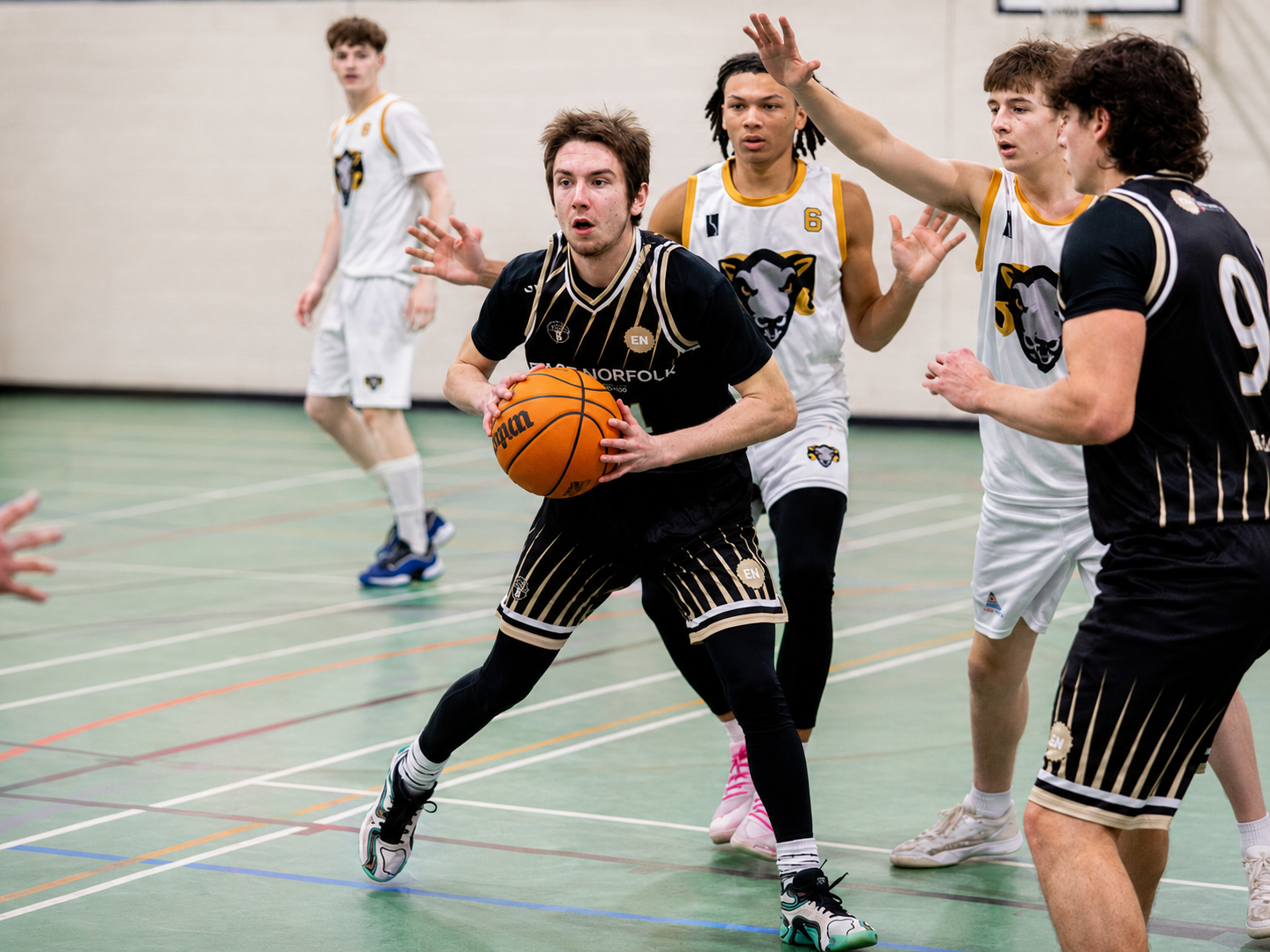 East Norfolk Basketball Academy player driving to the basket during a game.