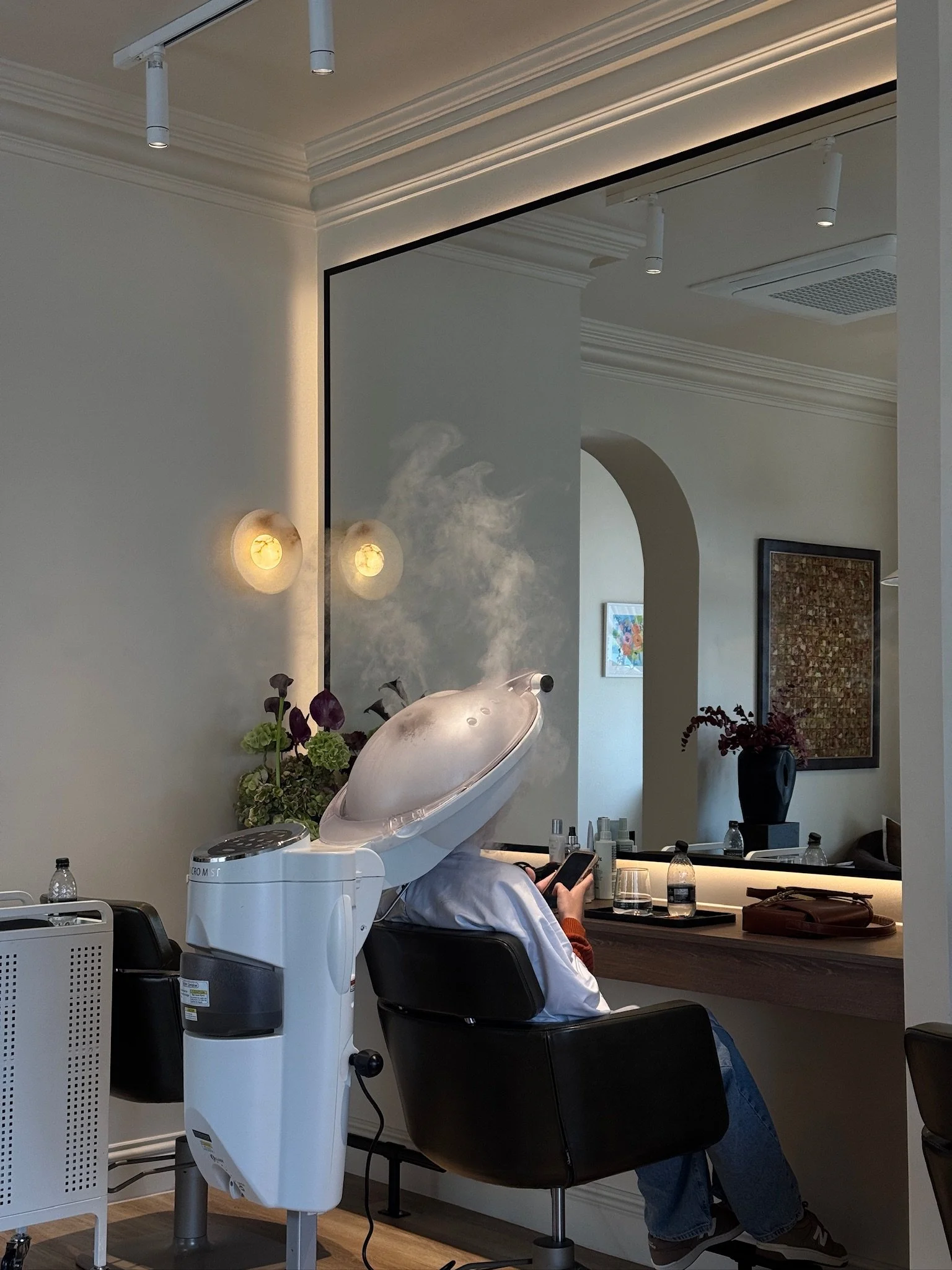 Client relaxing under a steam hair treatment during a hair spa service at Carmen Walker