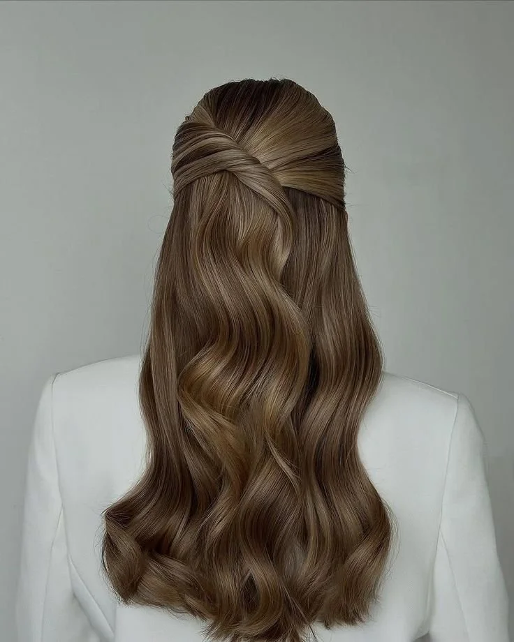 Soft half-up hairstyle with loose, natural waves, styled with gentle movement for festive occasions in a Leamington Spa hair salon.