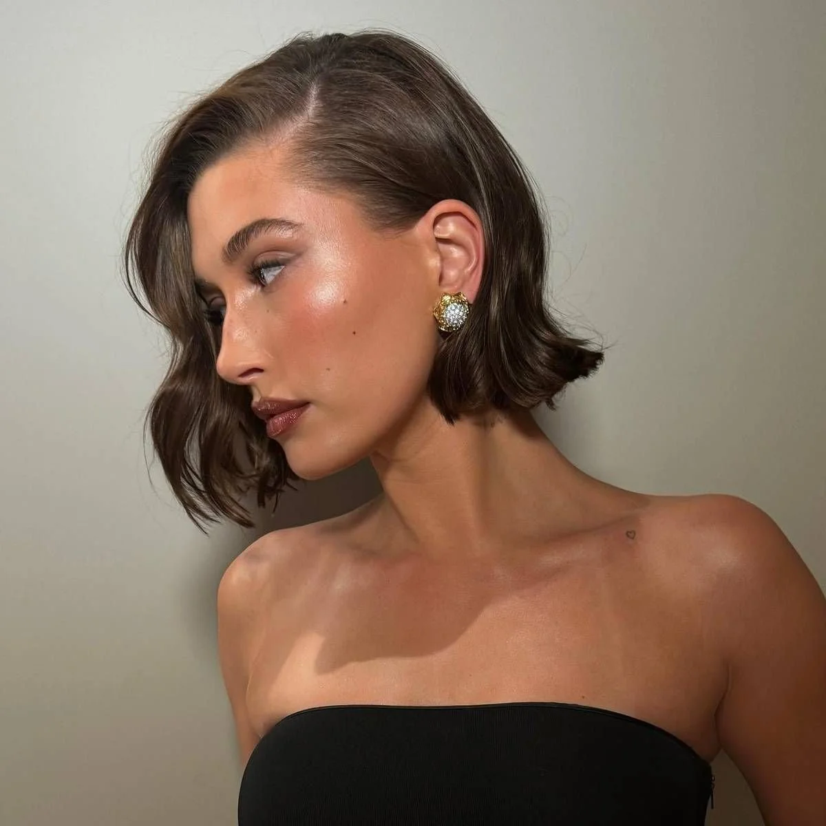 Softly styled short bob with smooth texture and gentle tuck, finished for festive hair styling.
