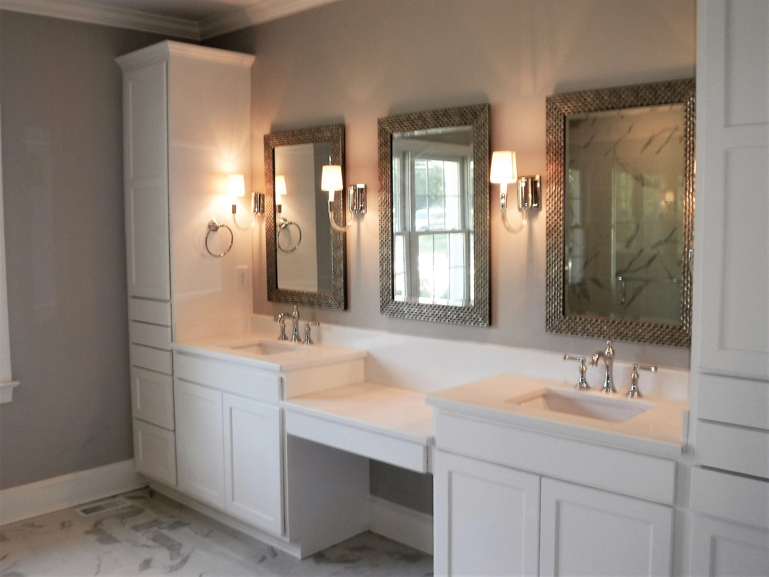 The large master bathroom incorporates and accessible shower, custom built vanity with a dressing table and herringbone tile design