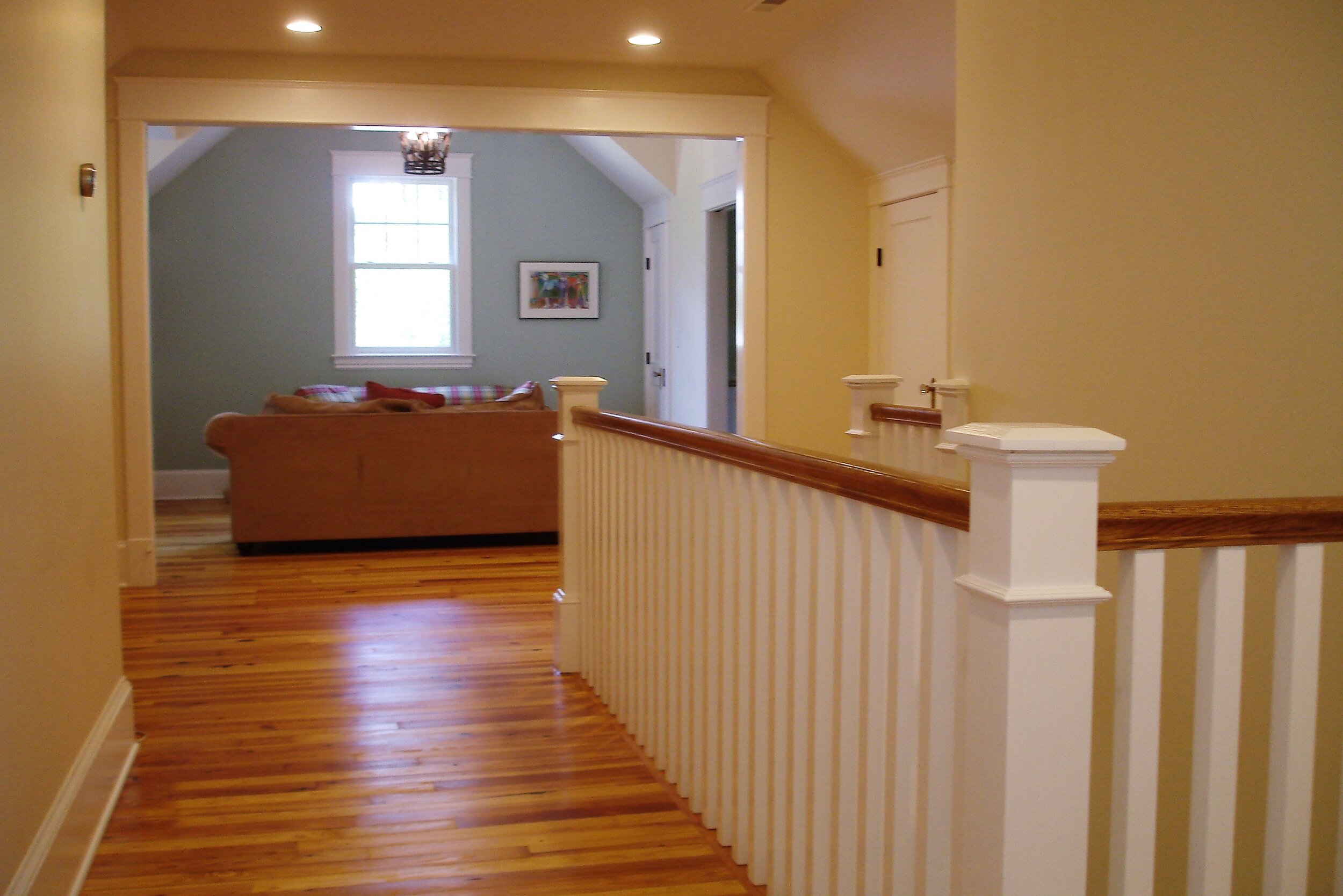 View of the upstairs rails and playroom with reclaimed heart pine floors.