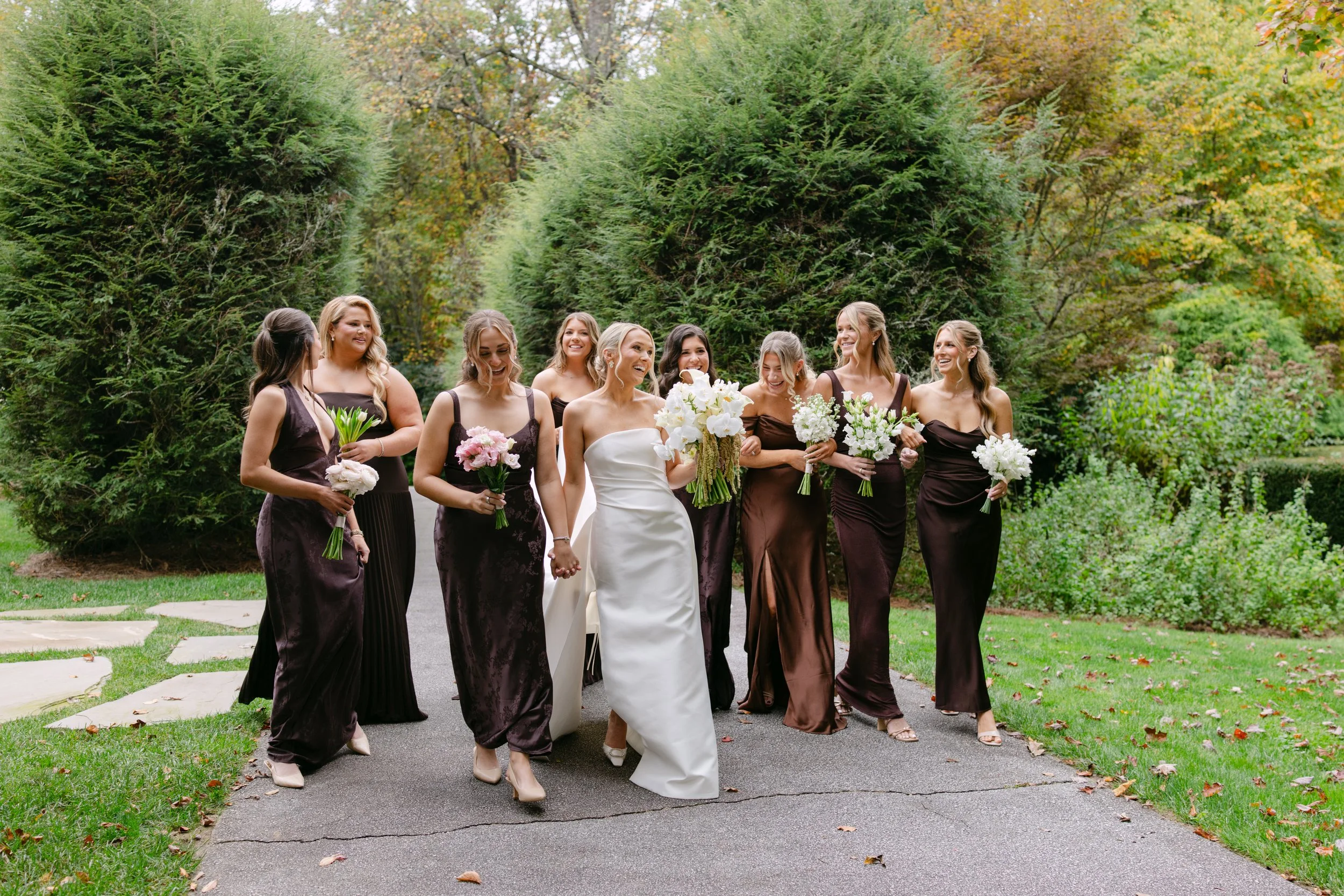 Bride and bridesmaids holding bouquets in a garden wedding portrait