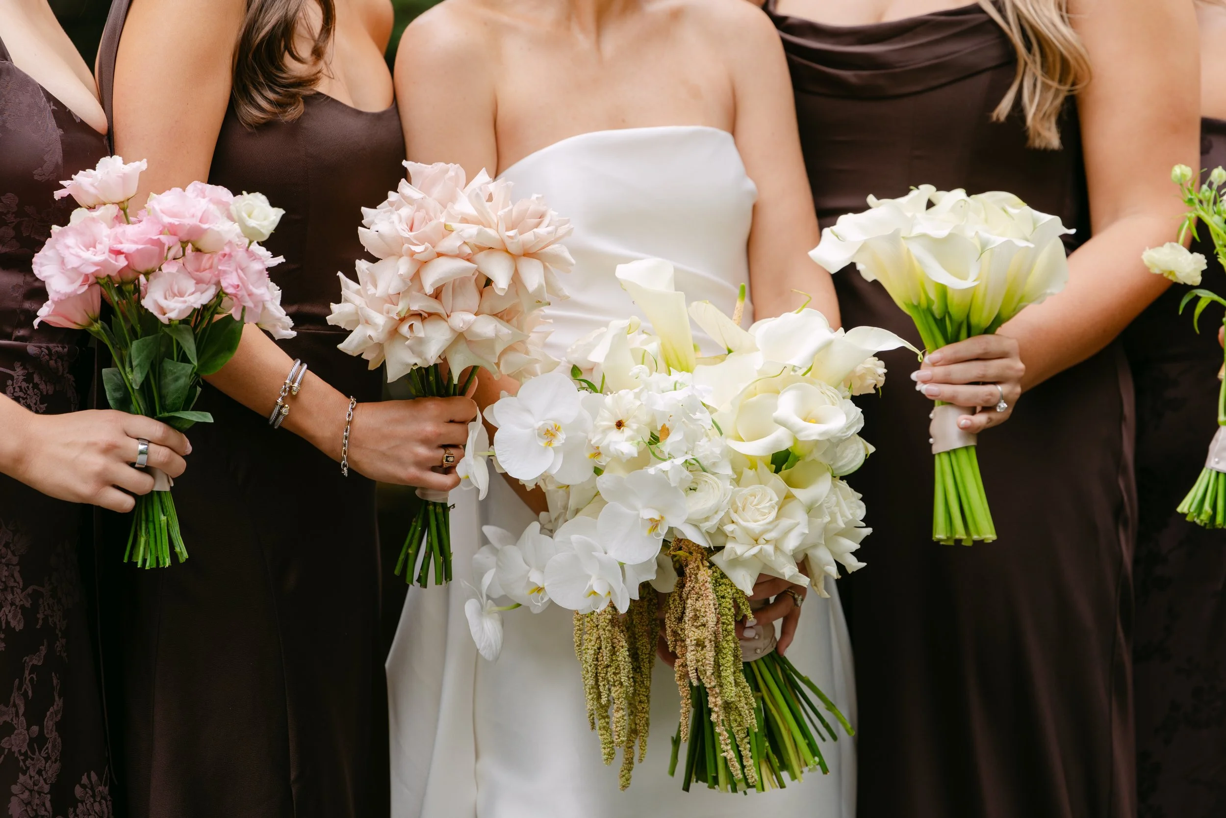 Bride and bridesmaids holding elegant pink and white wedding bouquets