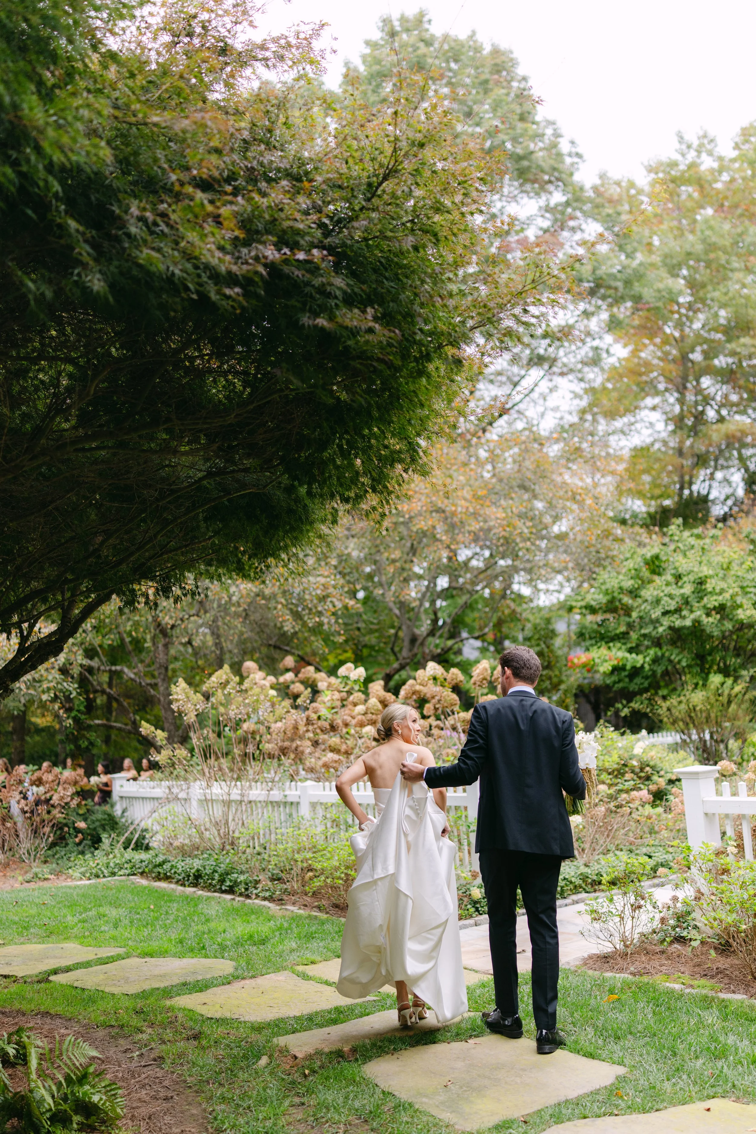 Bride and groom walking through a lush garden wedding venue