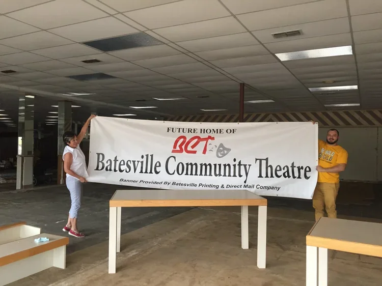 Board members Tommie McDonald and Colyn Bowman hold a banner in the future Batesville Community Theatre Performing Arts Center