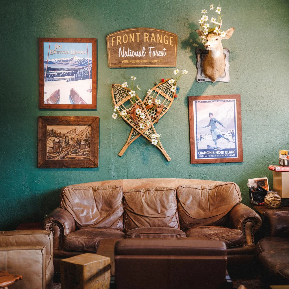 Seating area at Front Range KC with a leather couch and vintage mountain decor