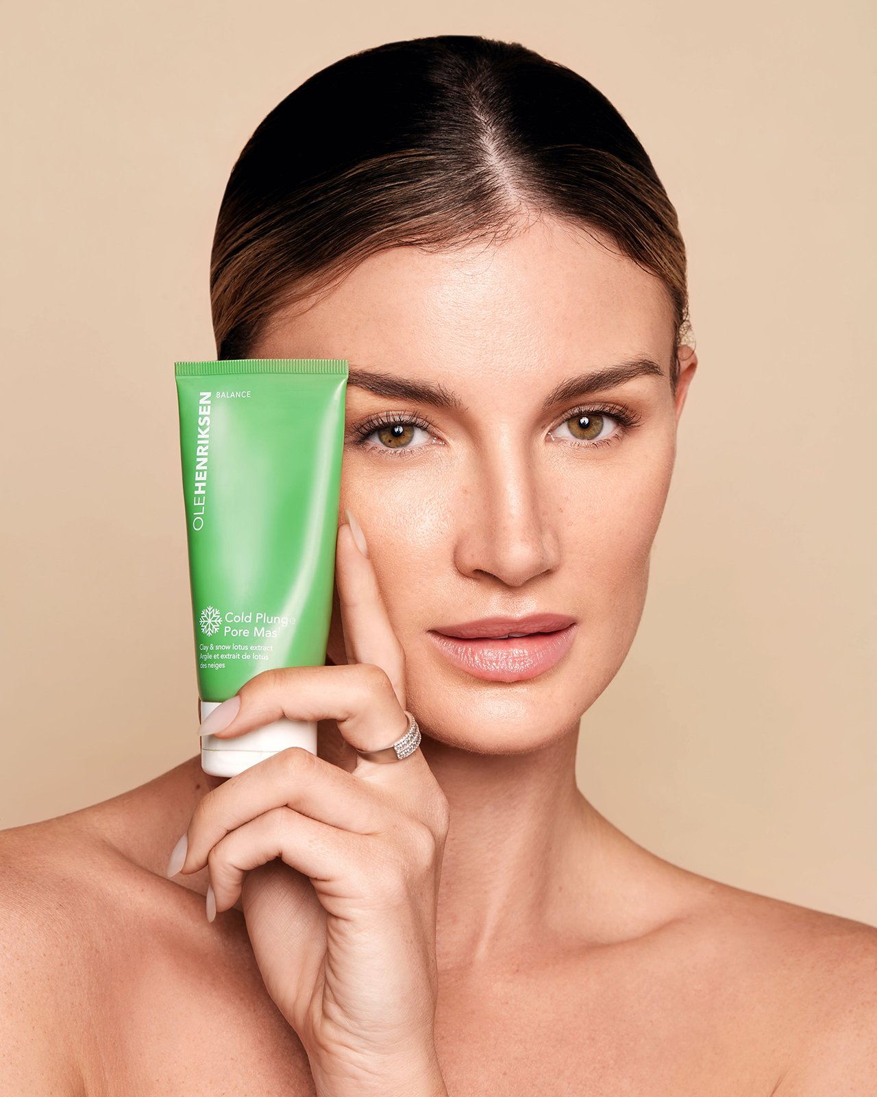 Person holding Ole Henriksen Cold Plunge Pore Mask tube near their face.