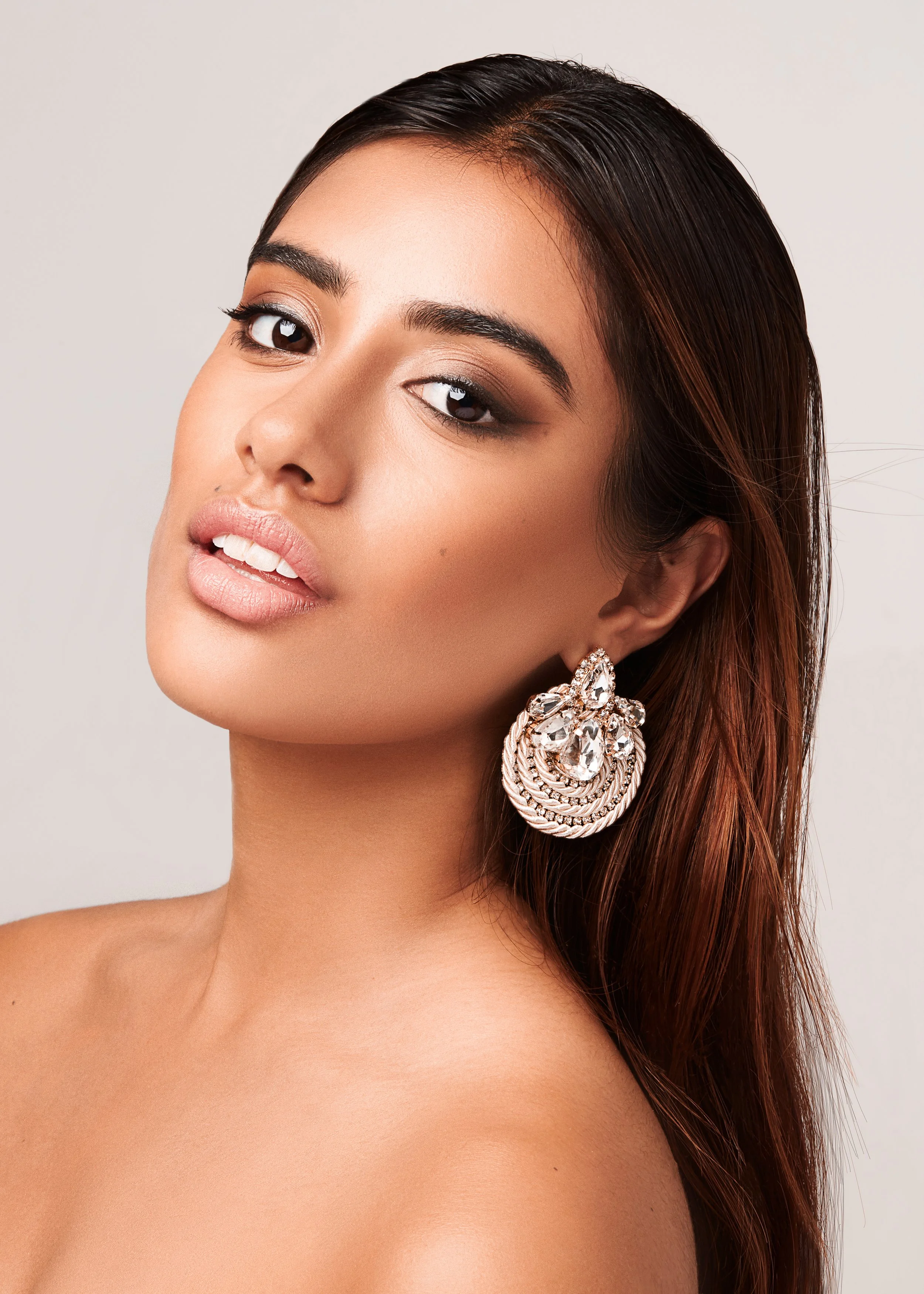 Woman with large decorative earrings and smooth makeup