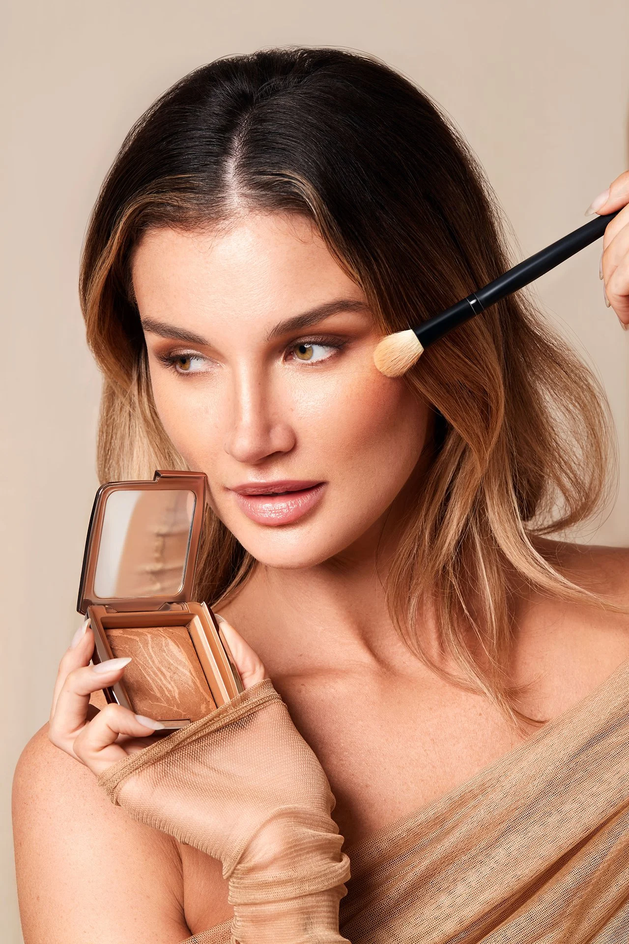 Person applying bronzer with a makeup brush