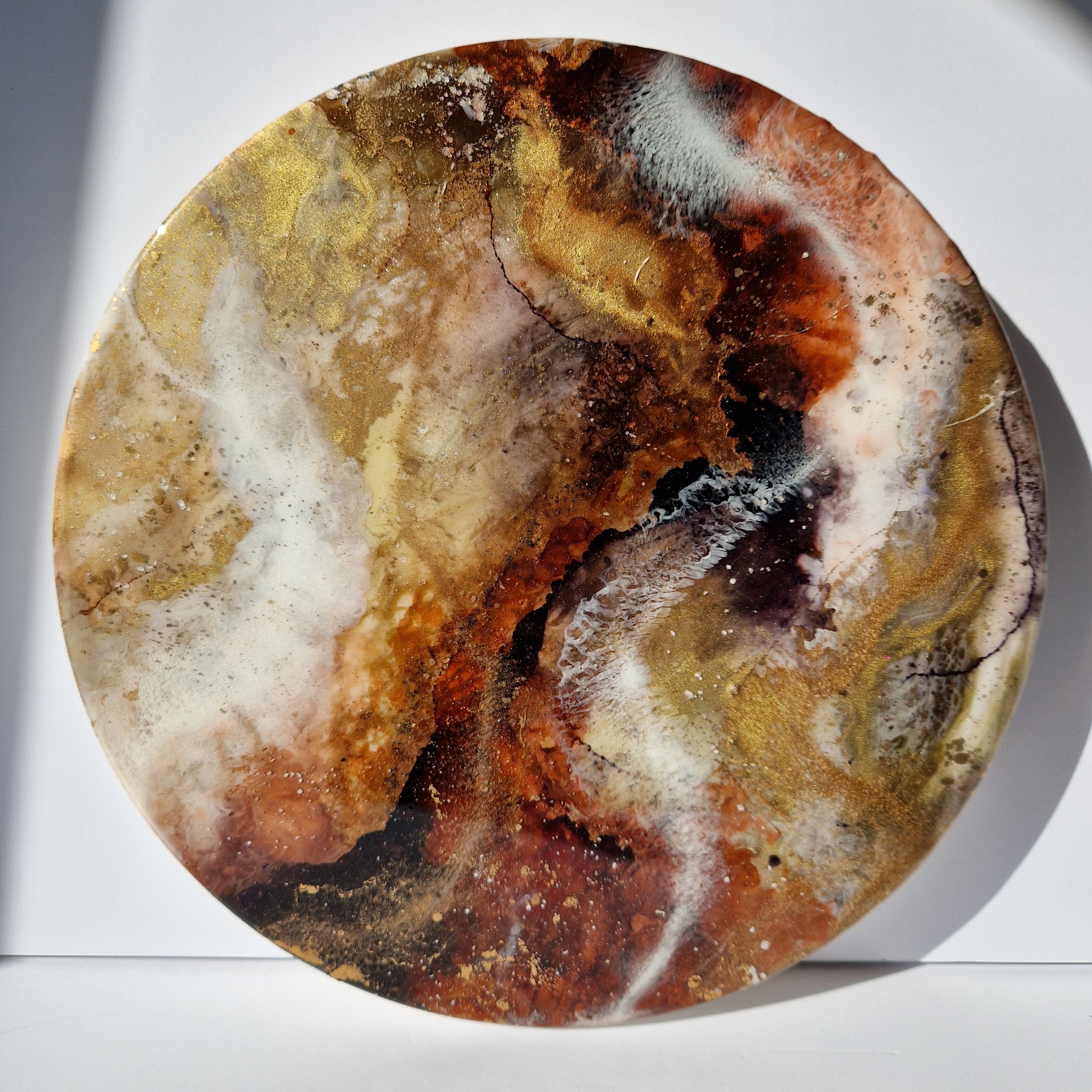 Coffee inspired round wall art inspired by the rich, warm hues of coffee. The piece is made from resin and mixed media materials. Perfect for adding a touch of organic art to any coffee lovers room.