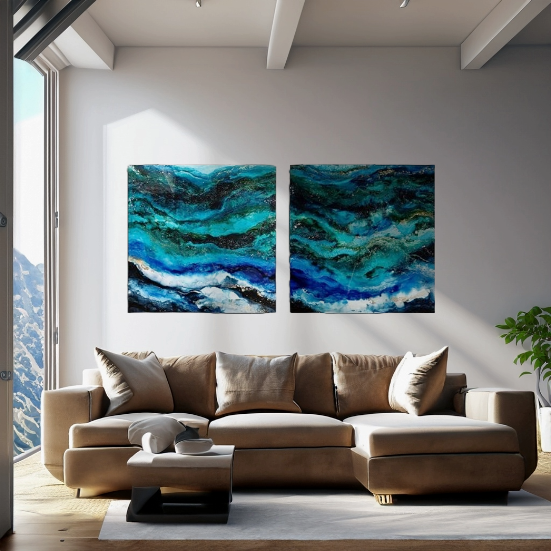 Living room with tan sectional sofa, abstract blue and teal ocean-inspired paintings on white wall, sunlight coming through a large window, and a potted plant in the corner.  Abstract ocean resin mixed media artwork created by UK based artist Katie A