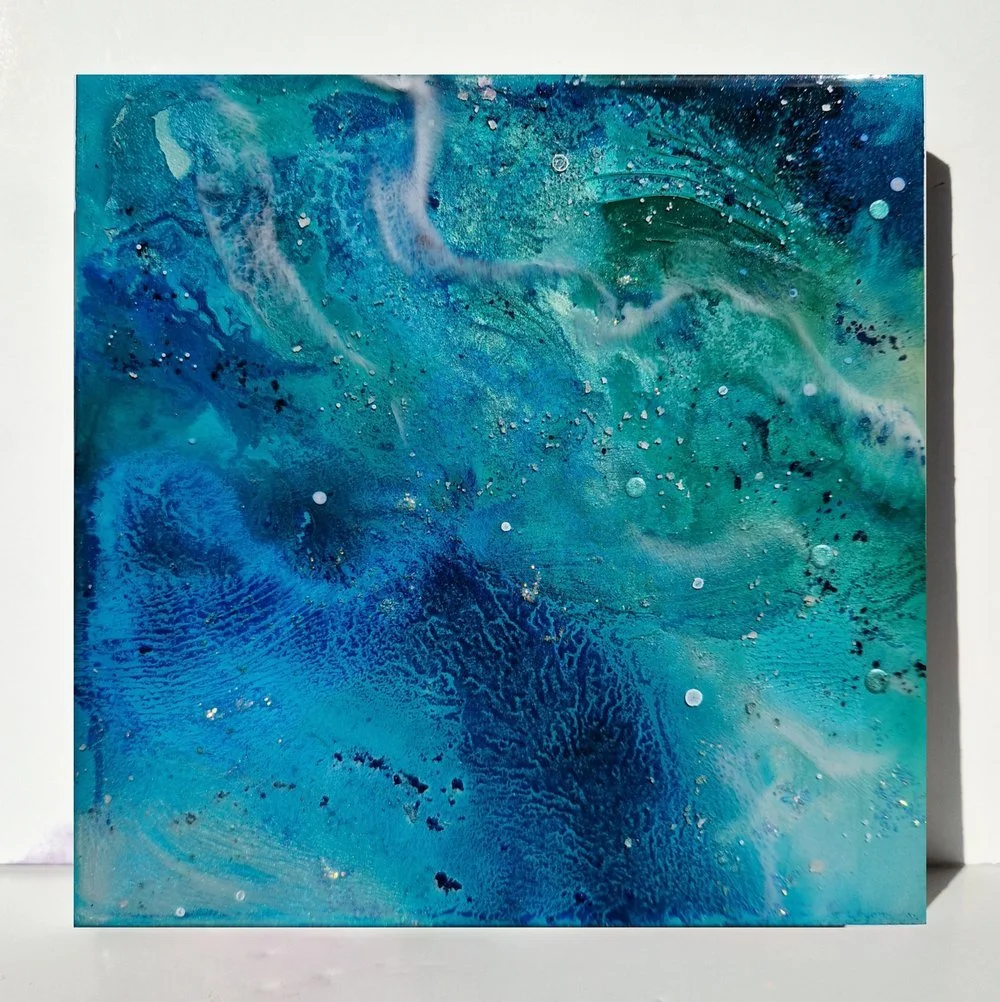 Circular blue resin abstract art with shades of blue, white, and black, ocean resin art, ocean epoxy art, ocean art, coastal decor, coastal art. Original bespoke abstract artwork created by artist Katie Alize, based in UK, Essex, London.