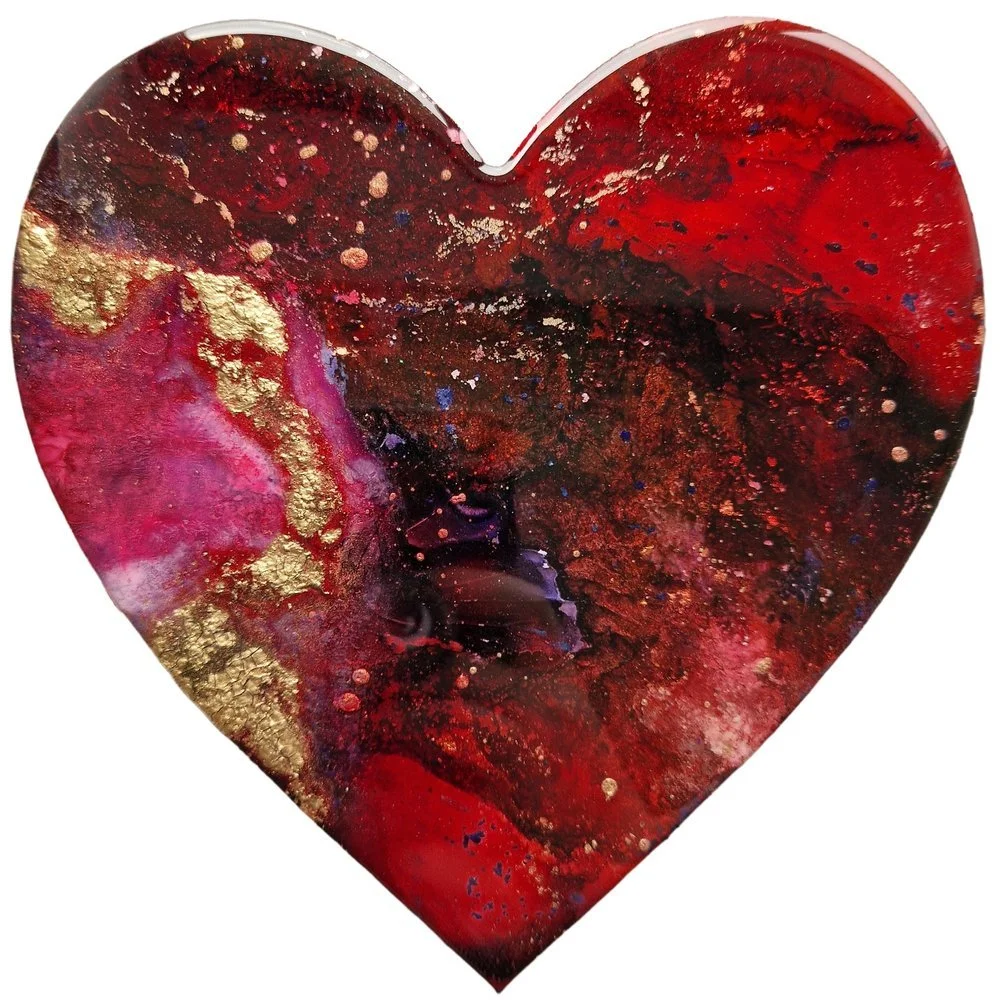 Decorative heart-shaped art piece with a red, gold, and black abstract pattern.