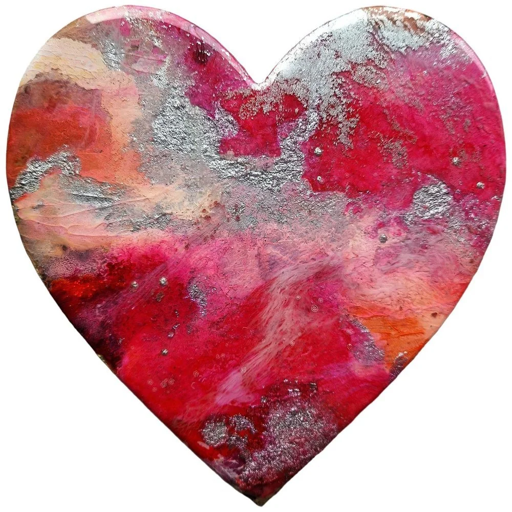 A painted heart-shaped piece of art with red, pink, orange, and purple colors, accented with silver and metallic textures.