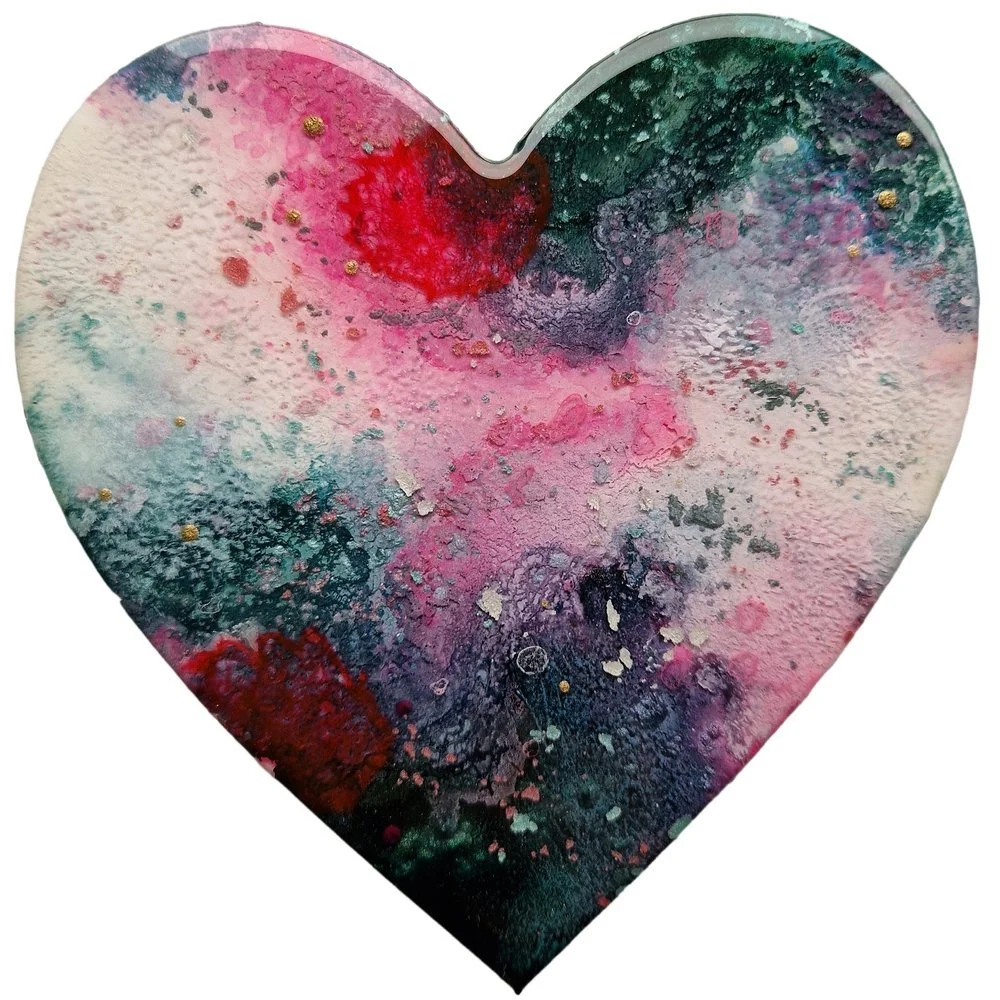 A heart-shaped piece of artwork with colorful splashes of pink, red, purple, blue, and black, resembling an abstract watercolor painting.