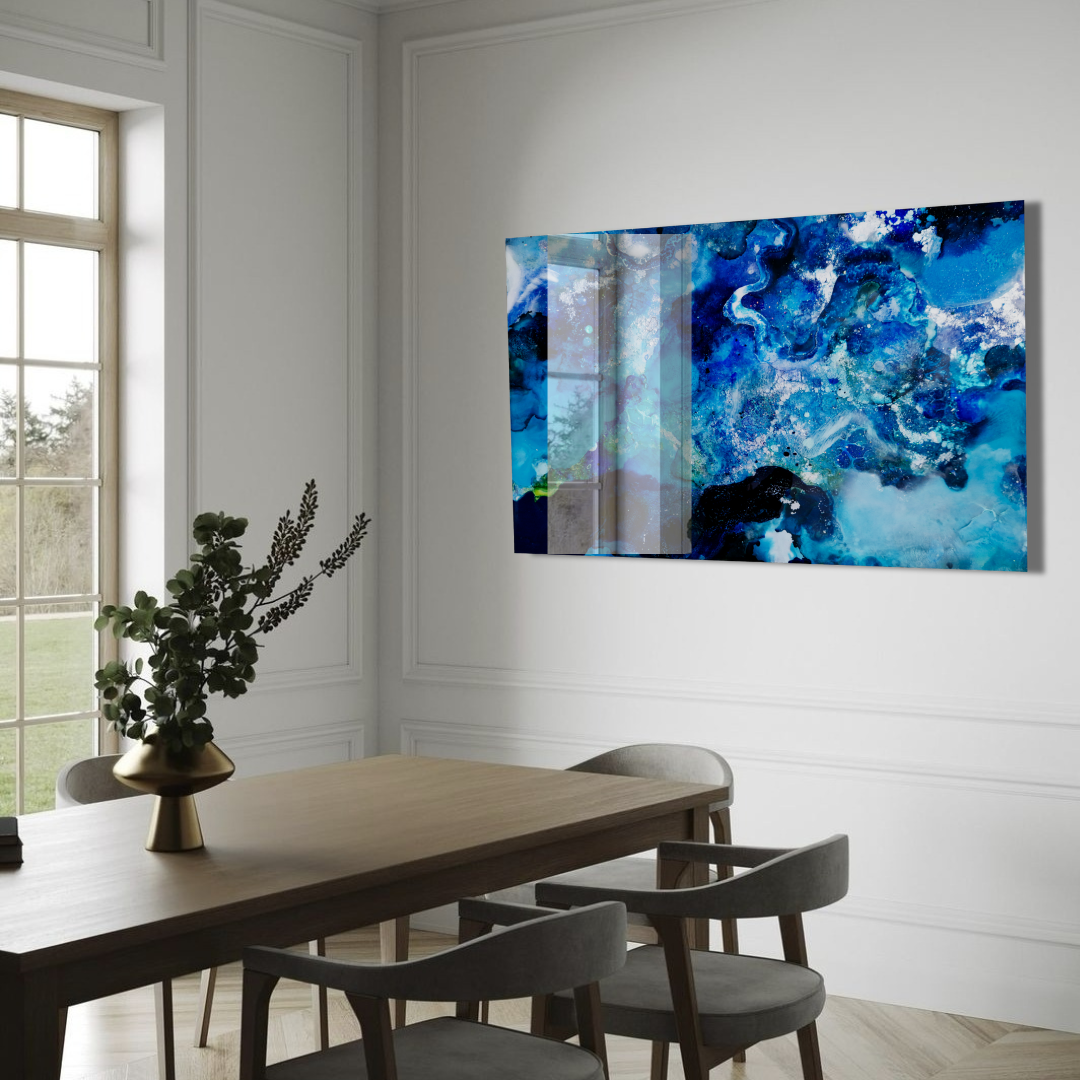 Modern dining room with a wooden table and four chairs, a decorative plant in a gold vase, and an abstract blue and white artwork on the wall.  Abstract ocean resin mixed media artwork created by UK based artist Katie Alize