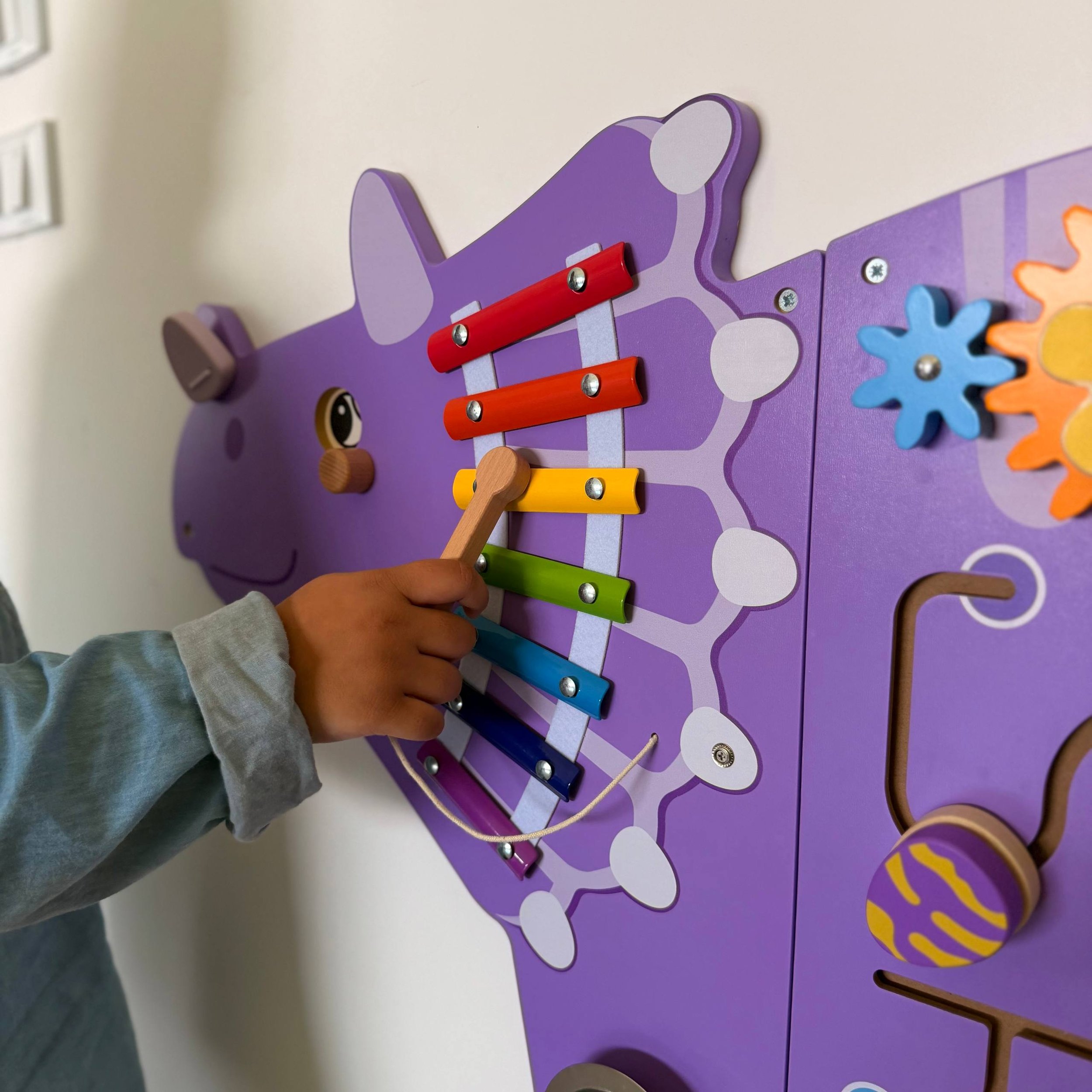 Child Playing with Dinosaur Xylophone Busyboard