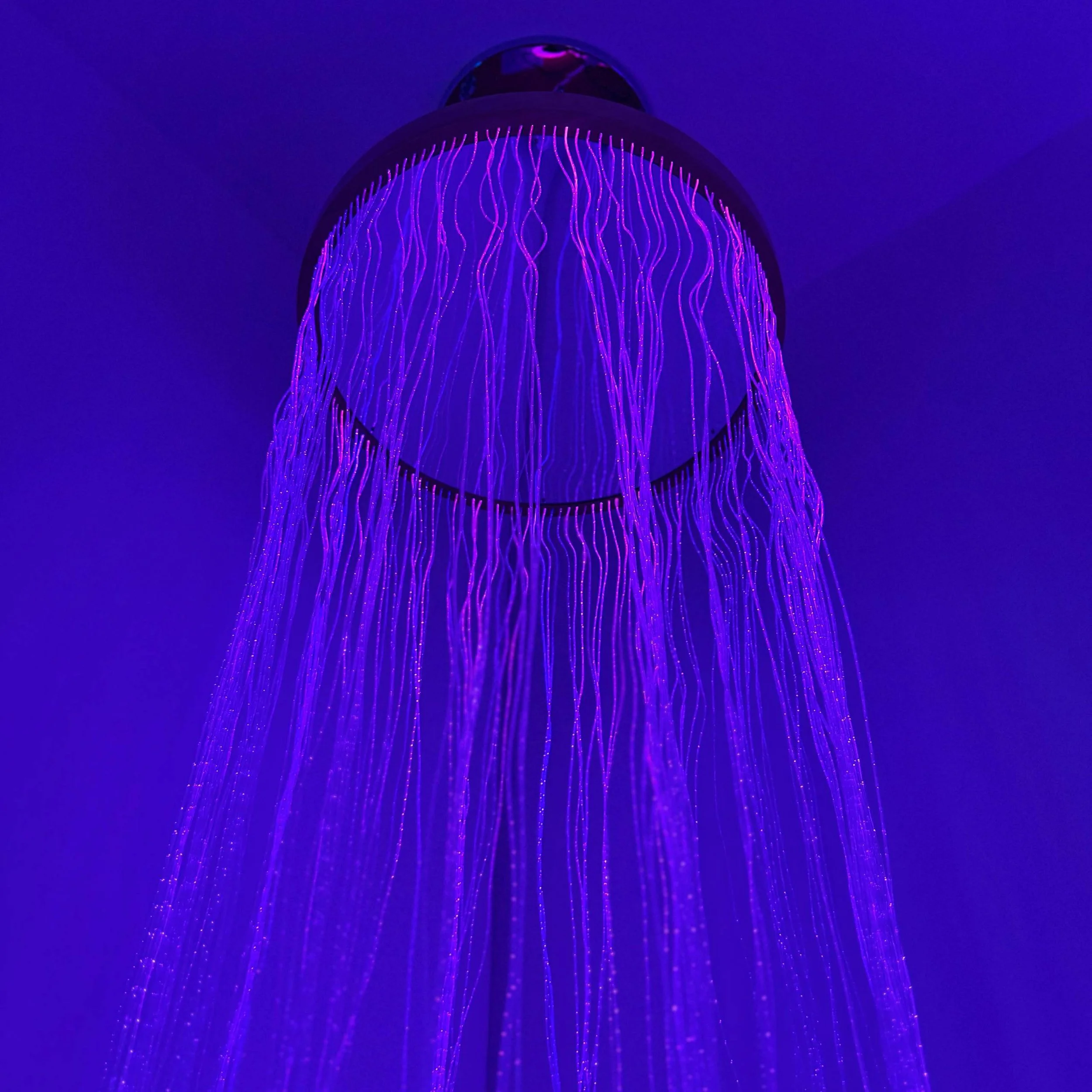 Color-changing LED fiber optic curtain with cascading illuminated strands, designed to create a calming, interactive sensory experience in sensory rooms, therapy spaces, and special education environments.