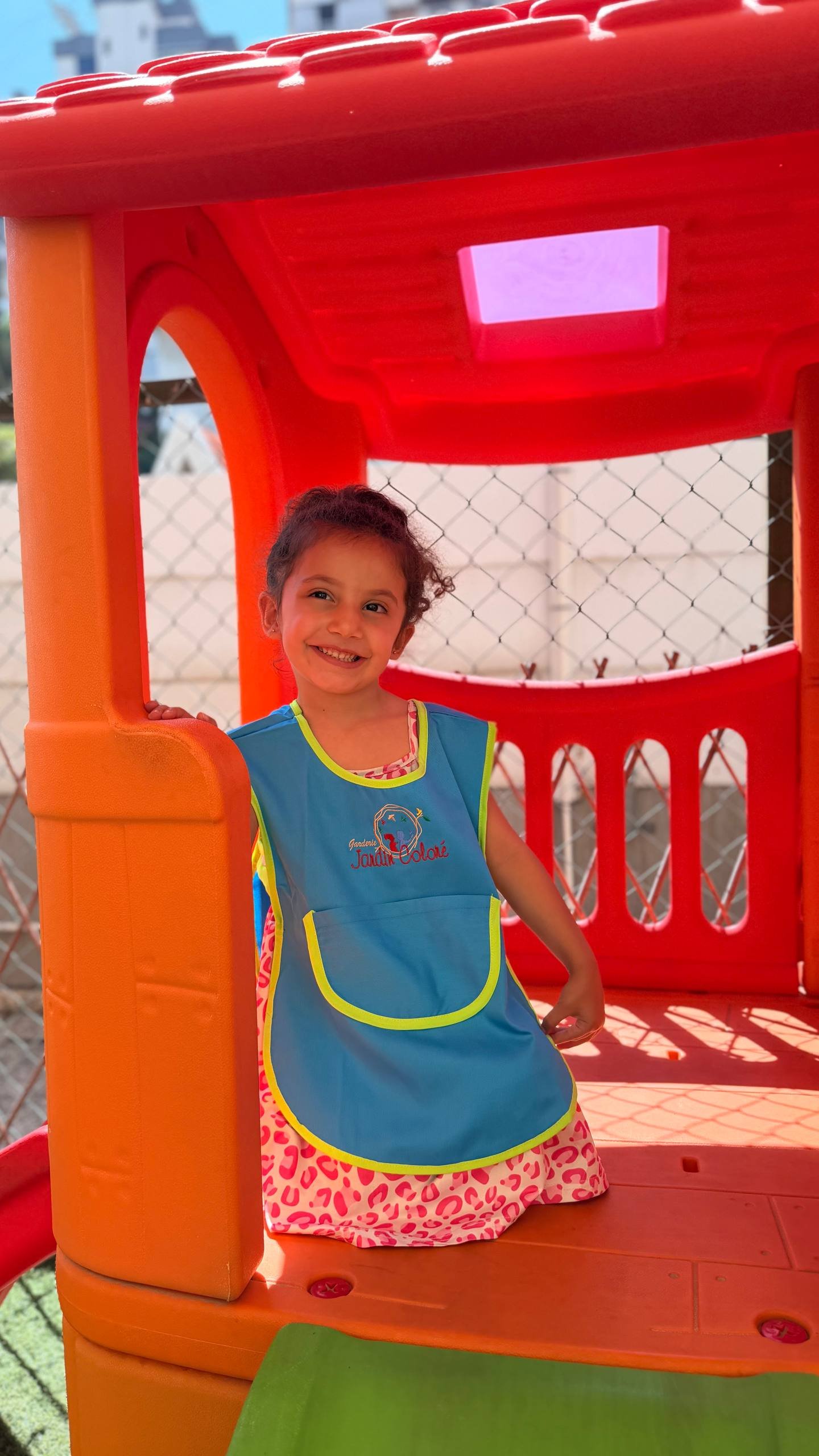 Child wearing a colorful kindergarten apron designed to protect clothing during classroom activities, arts and crafts, and early childhood learning.