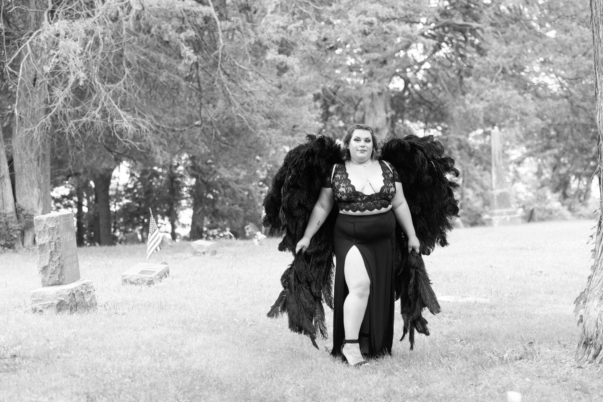  Samantha in black dress and black angel wings poses in cemetery. In black and white. 