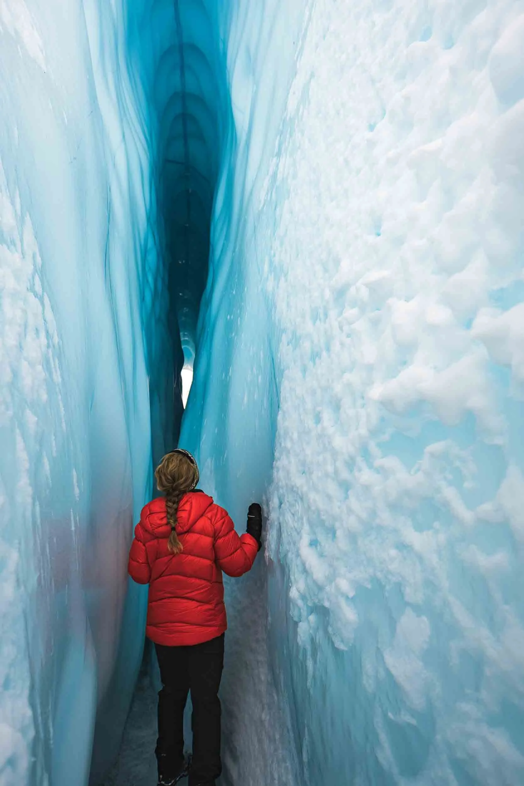 Woman standing in an ice cave on a commercial video shoot in Alaska showcasing high end video post production services.