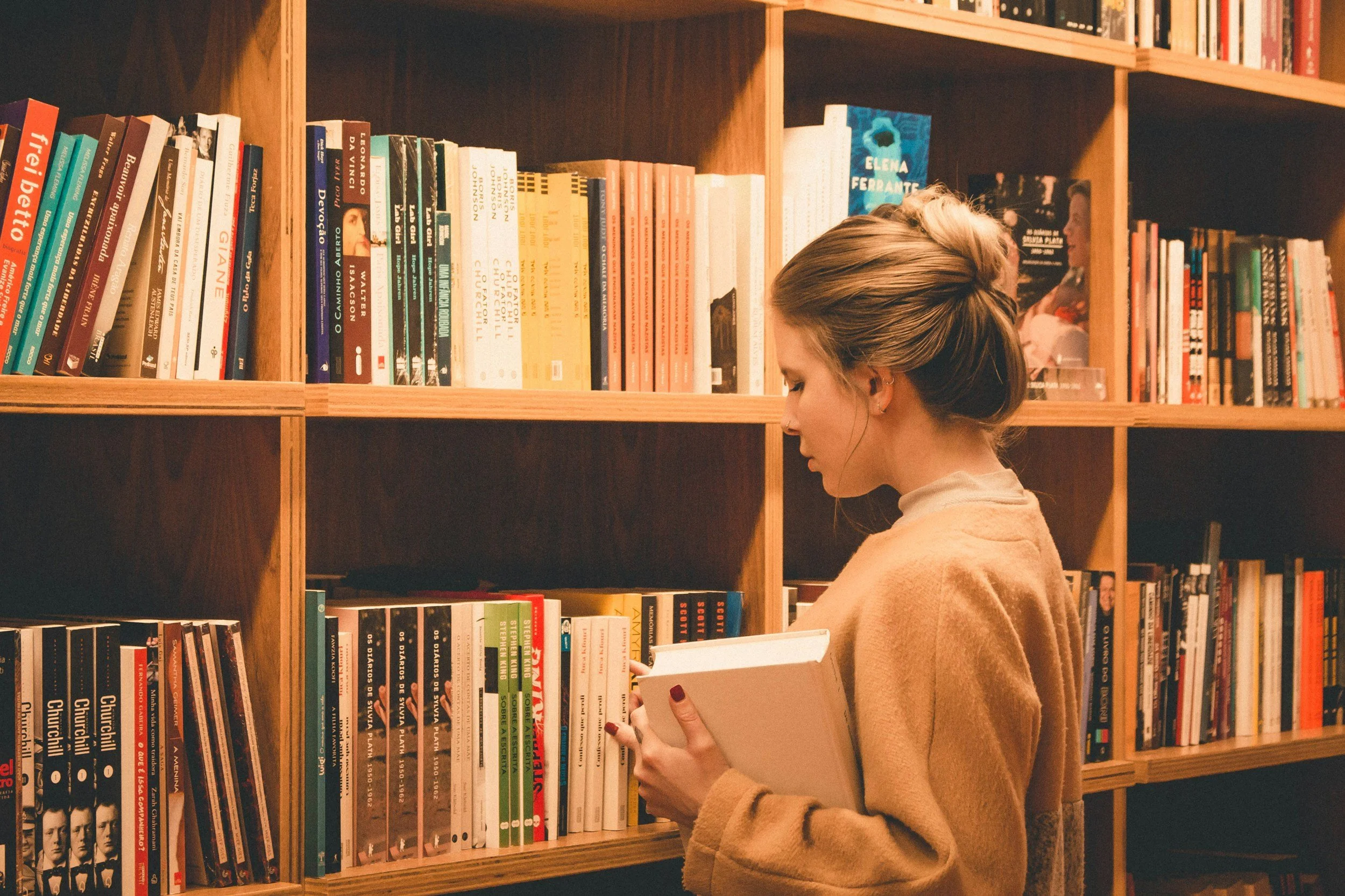 Woman looking at books on a bookshelf representing a woman after her therapy for anxiety therapy session in Salt Lake City, Utah.