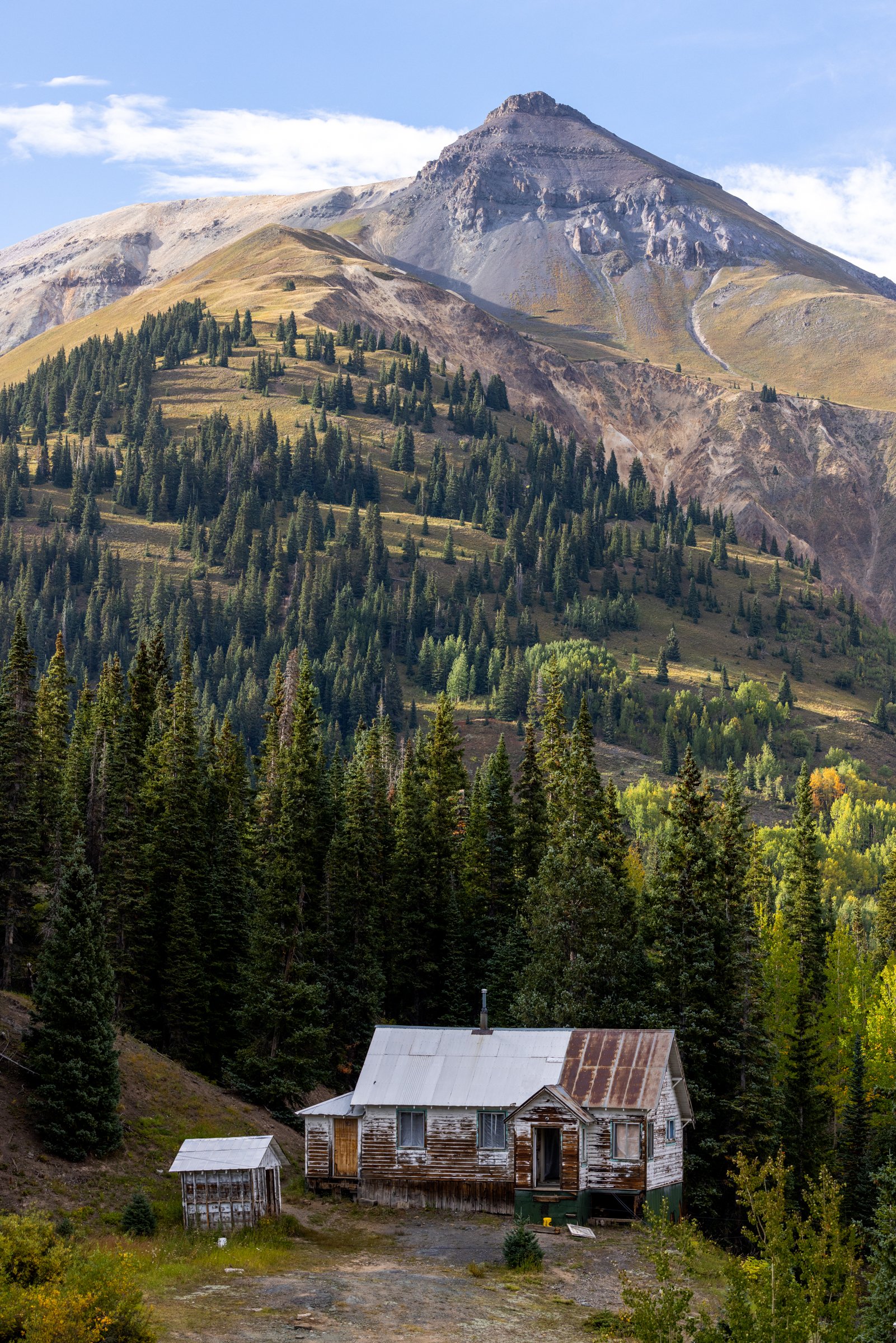 Idarado Miner's Cabin, Million Dollar Highway, 2022. A miner's cabin stands along the Million Dollar Highway between Ouray and Silverton in the San Juan Range. Small mining claims were often consolidated into large company holdings such as Idarado. T