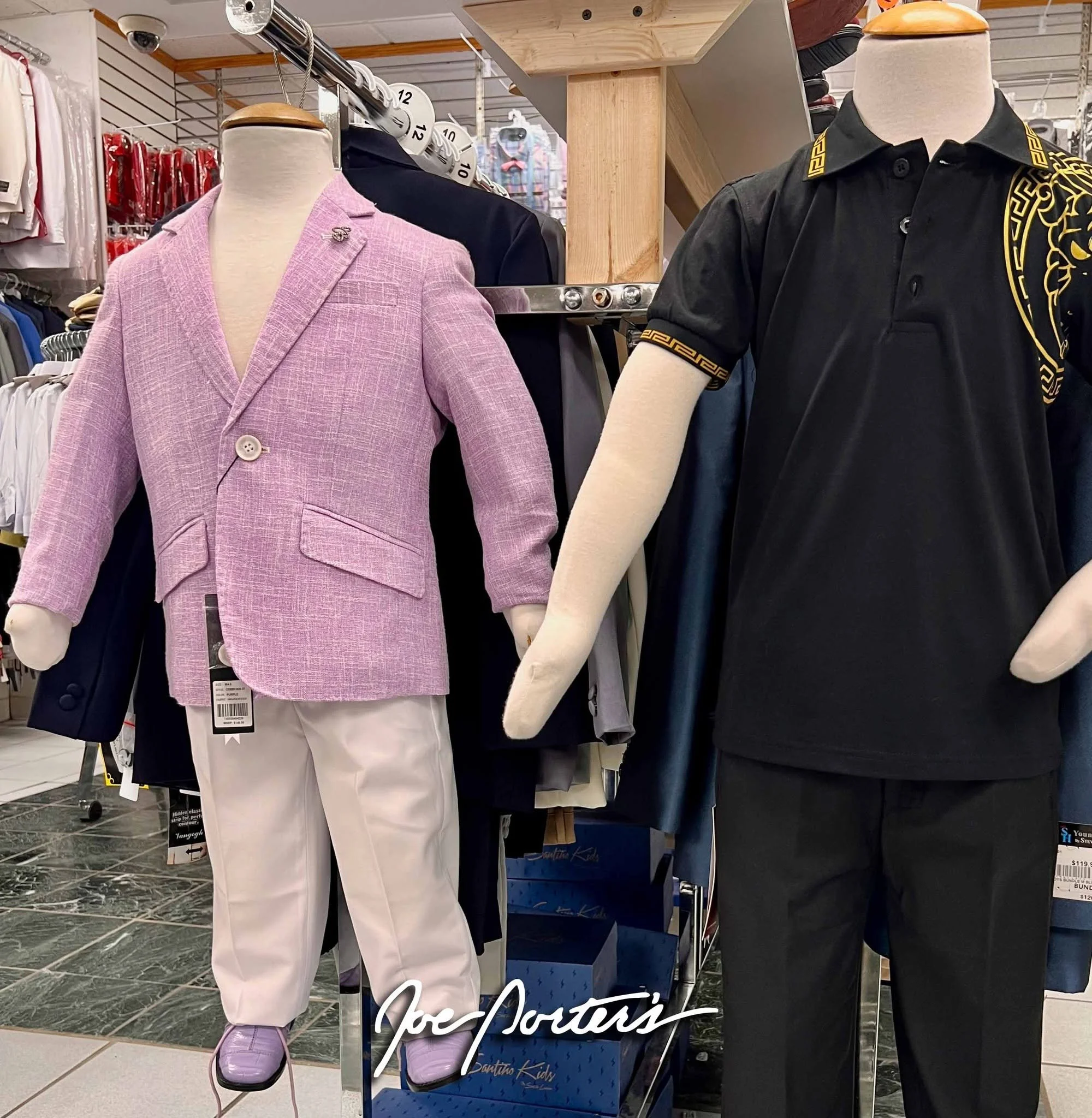 Store display featuring mannequins in a lavender blazer and white pants, and a black polo shirt with gold baroque trim