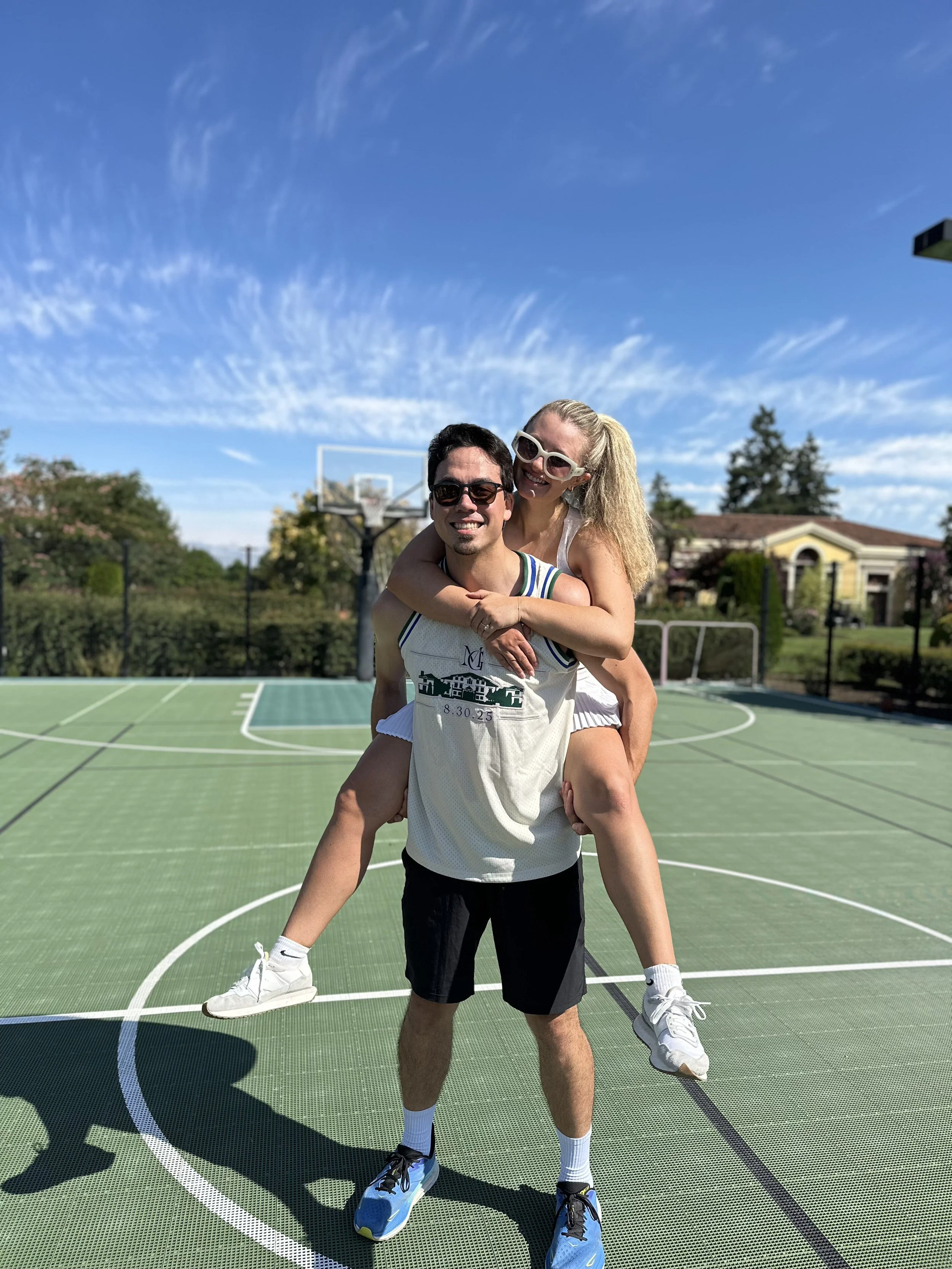 Groom gives bride piggie back ride at morning workout class