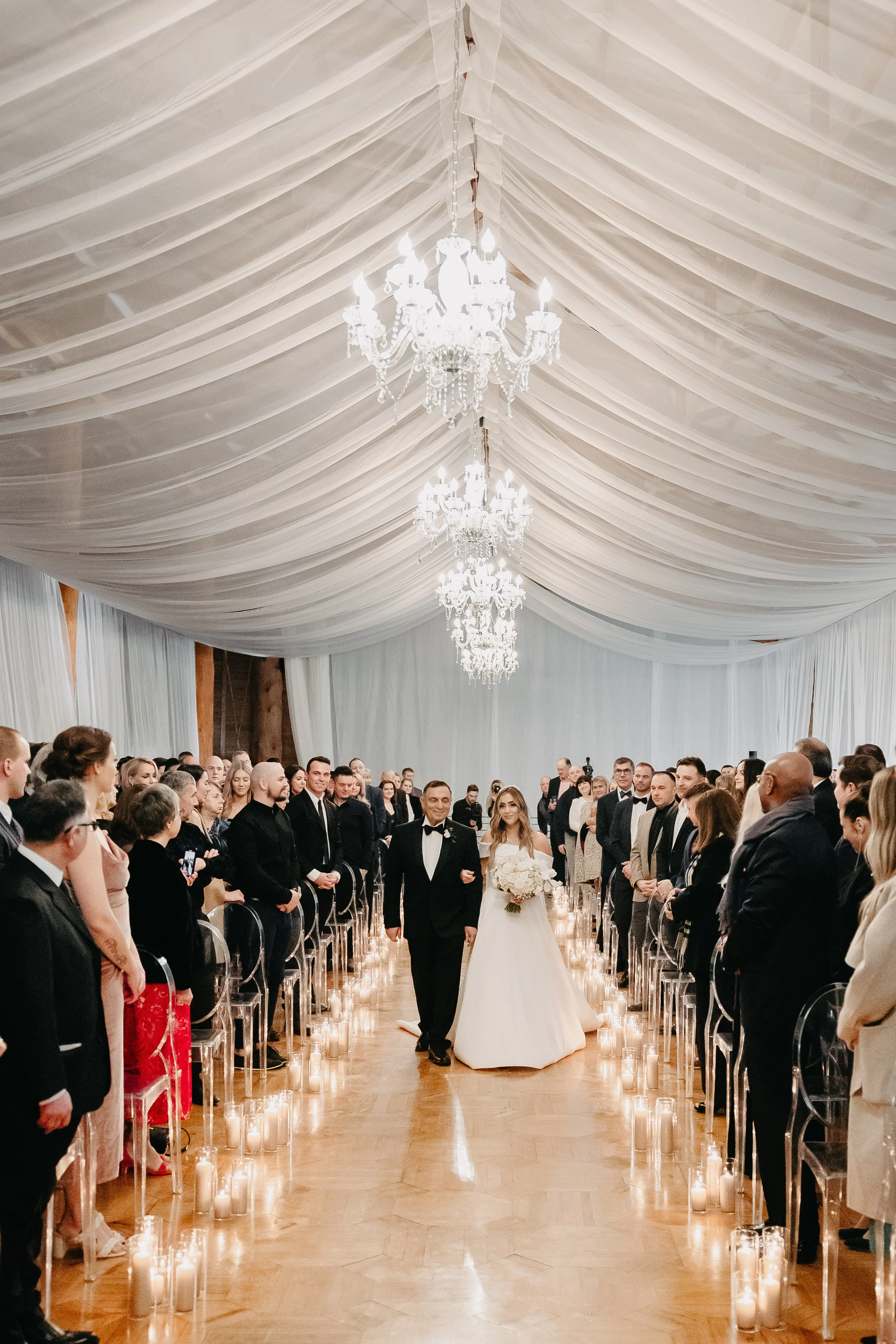 father walking bride down candle lit aisle for a winter wedding at maysara winery