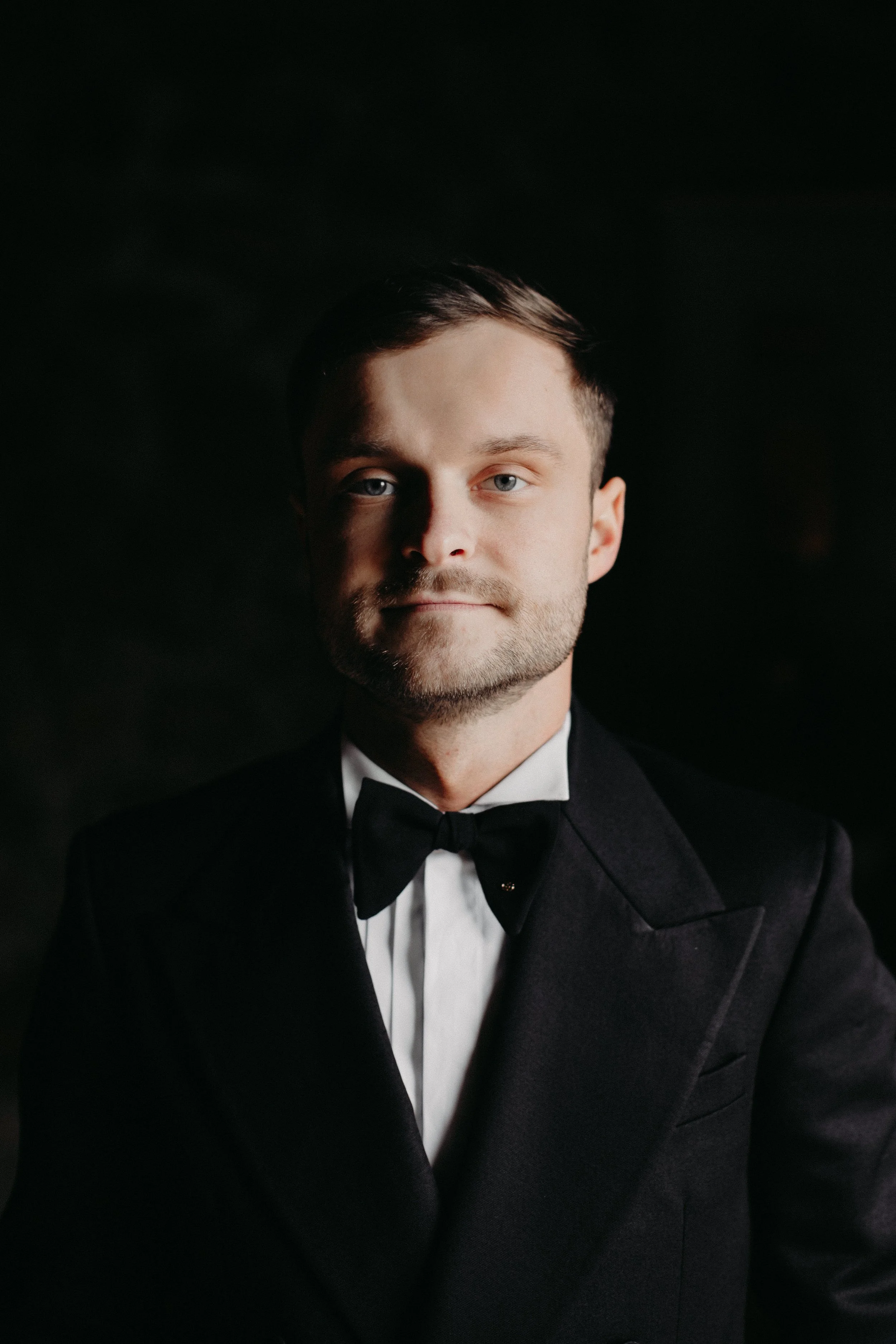 Moody portrait of groom in a black tuxedo at Maysara Winery
