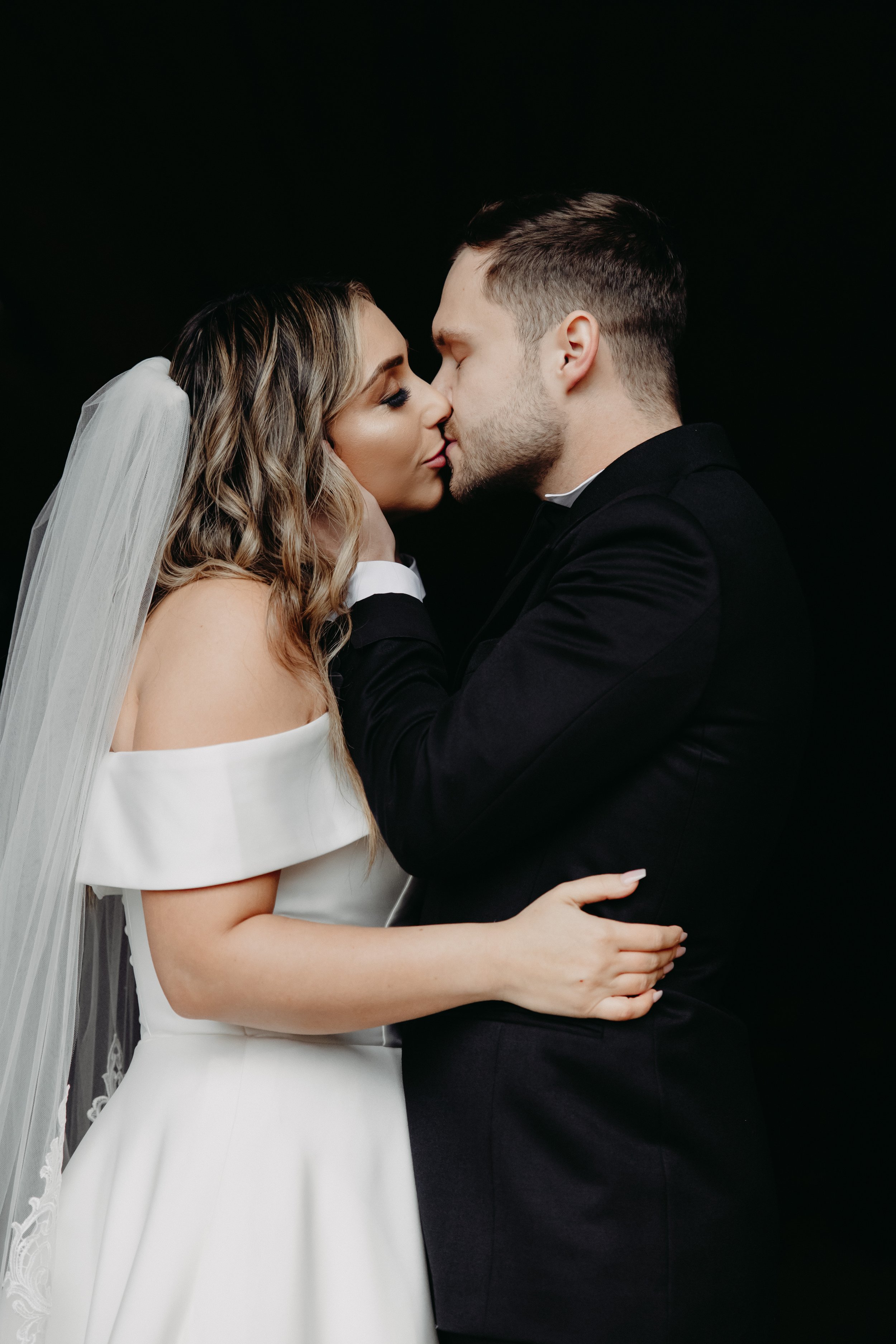 Bride and groom kissing during portraits before winter wedding at Maysara Winery