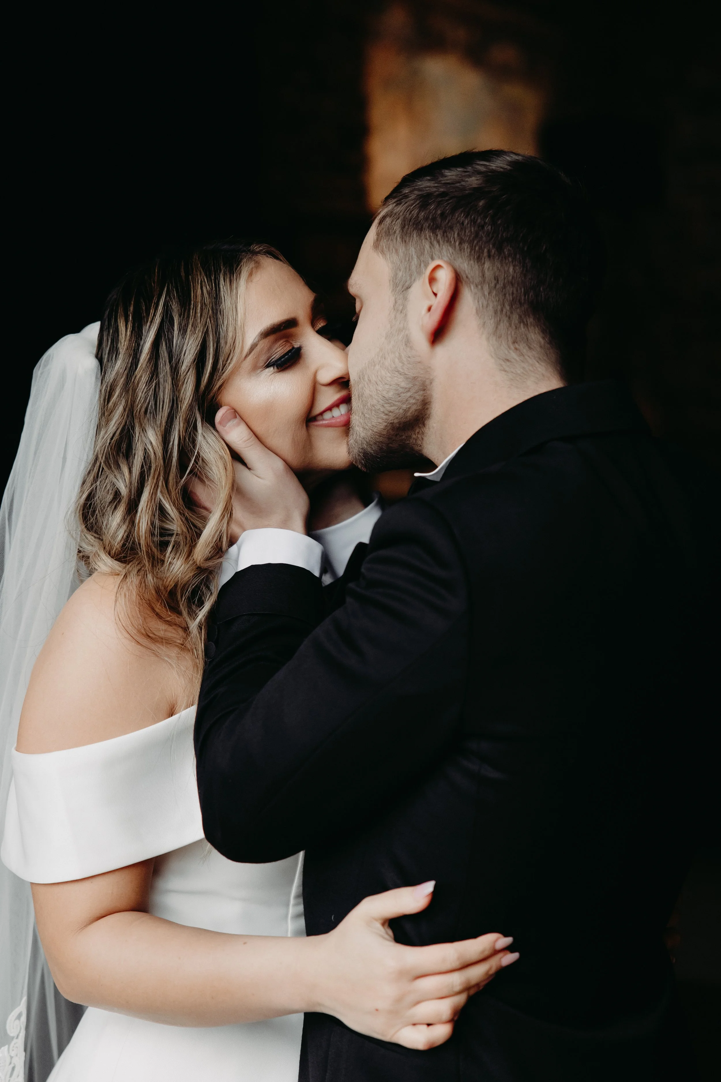 Bride and groom kissing and smiling during portraits before winter wedding at Maysara Winery
