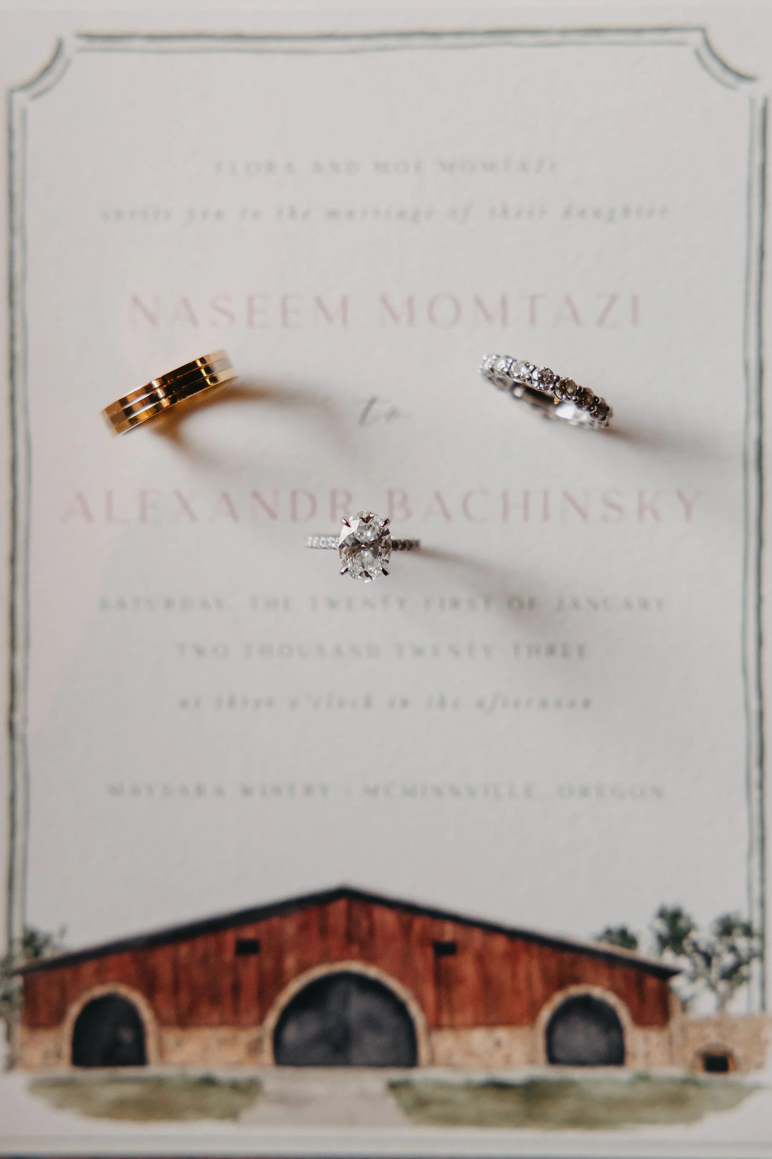 Watercolor wedding invitation painting of Maysara Winery with wedding bands stacked on top