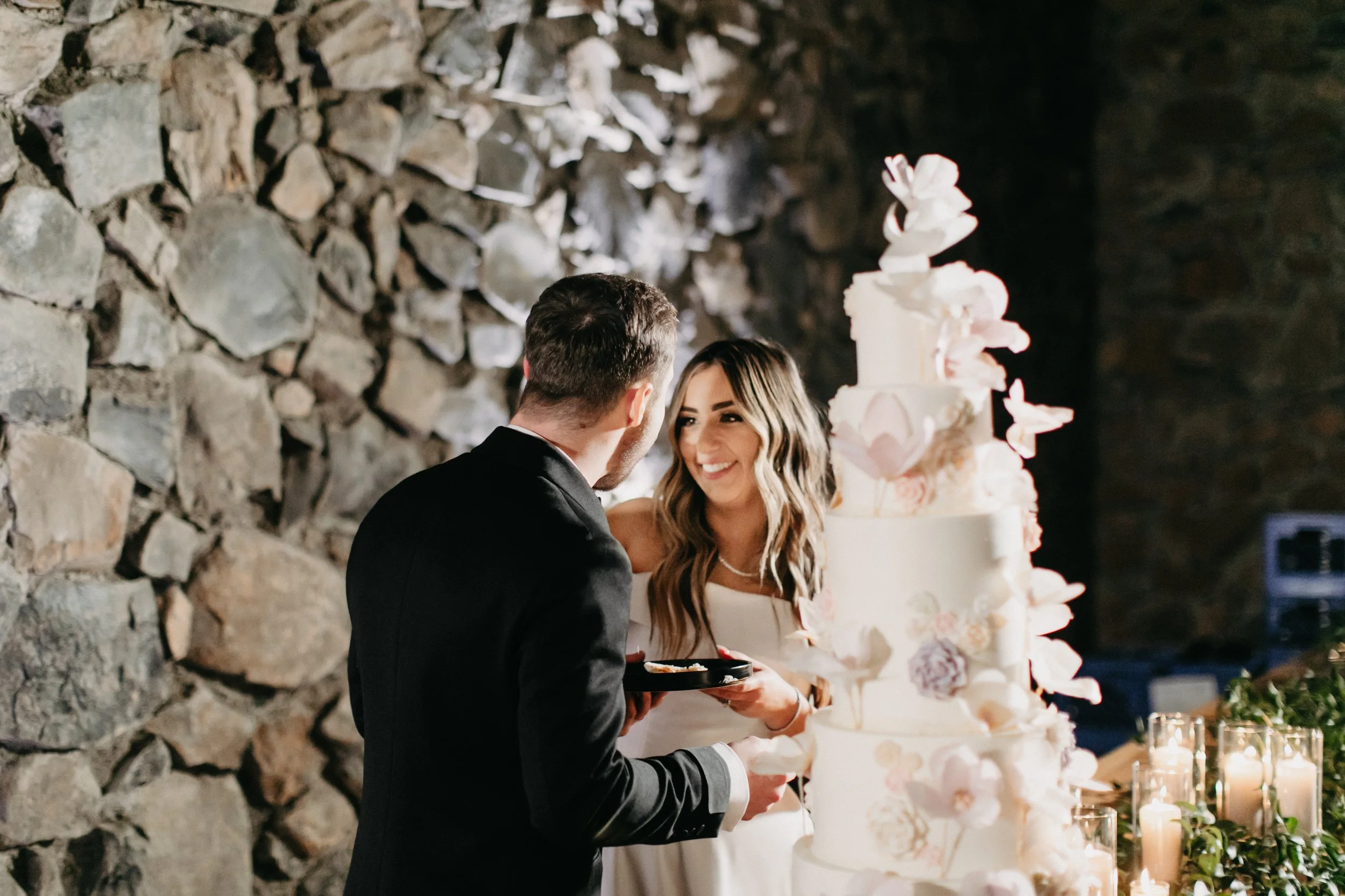 Bride feeding groom wedding cake at winter wedding