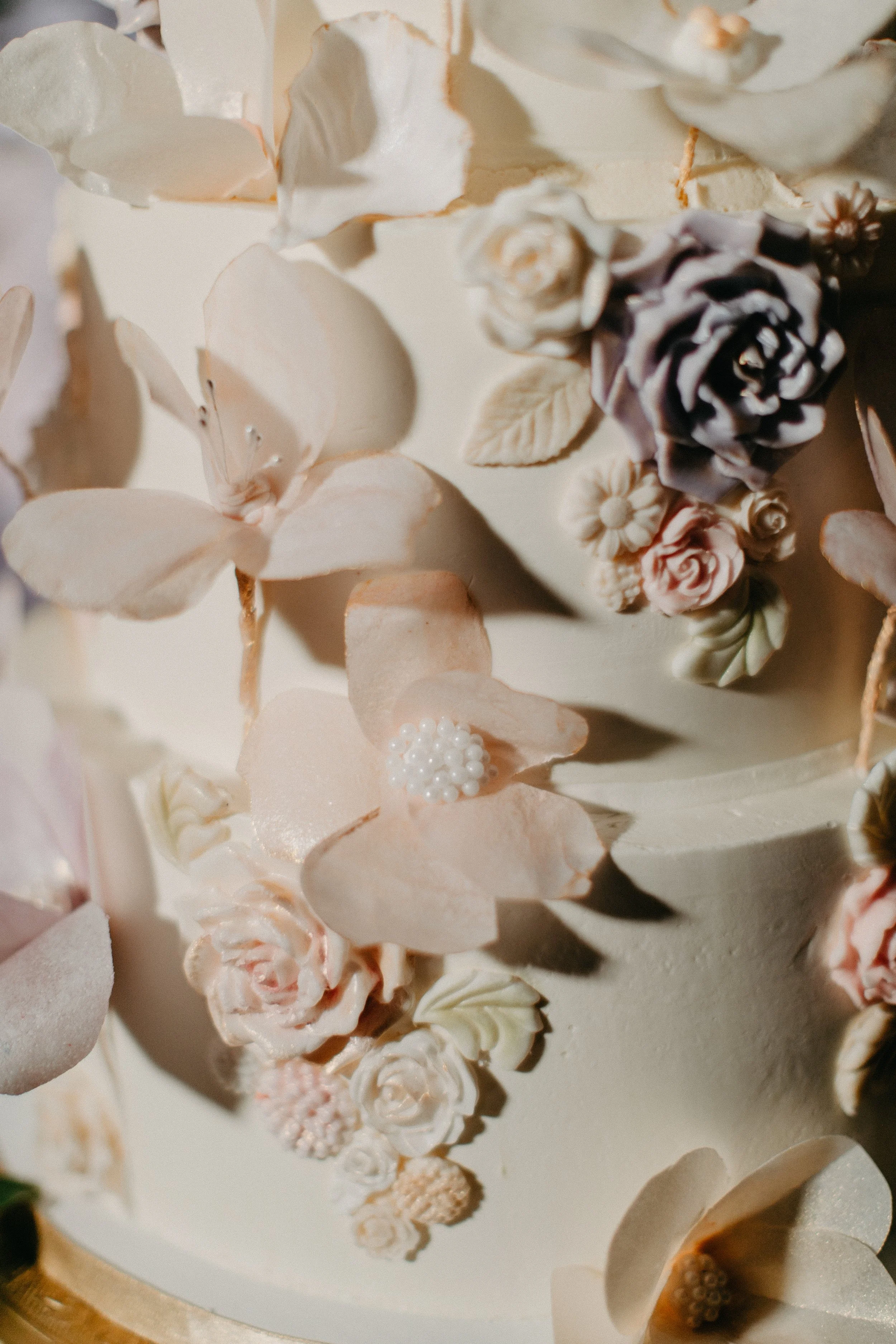 Close up of sugar flowers on white wedding cake