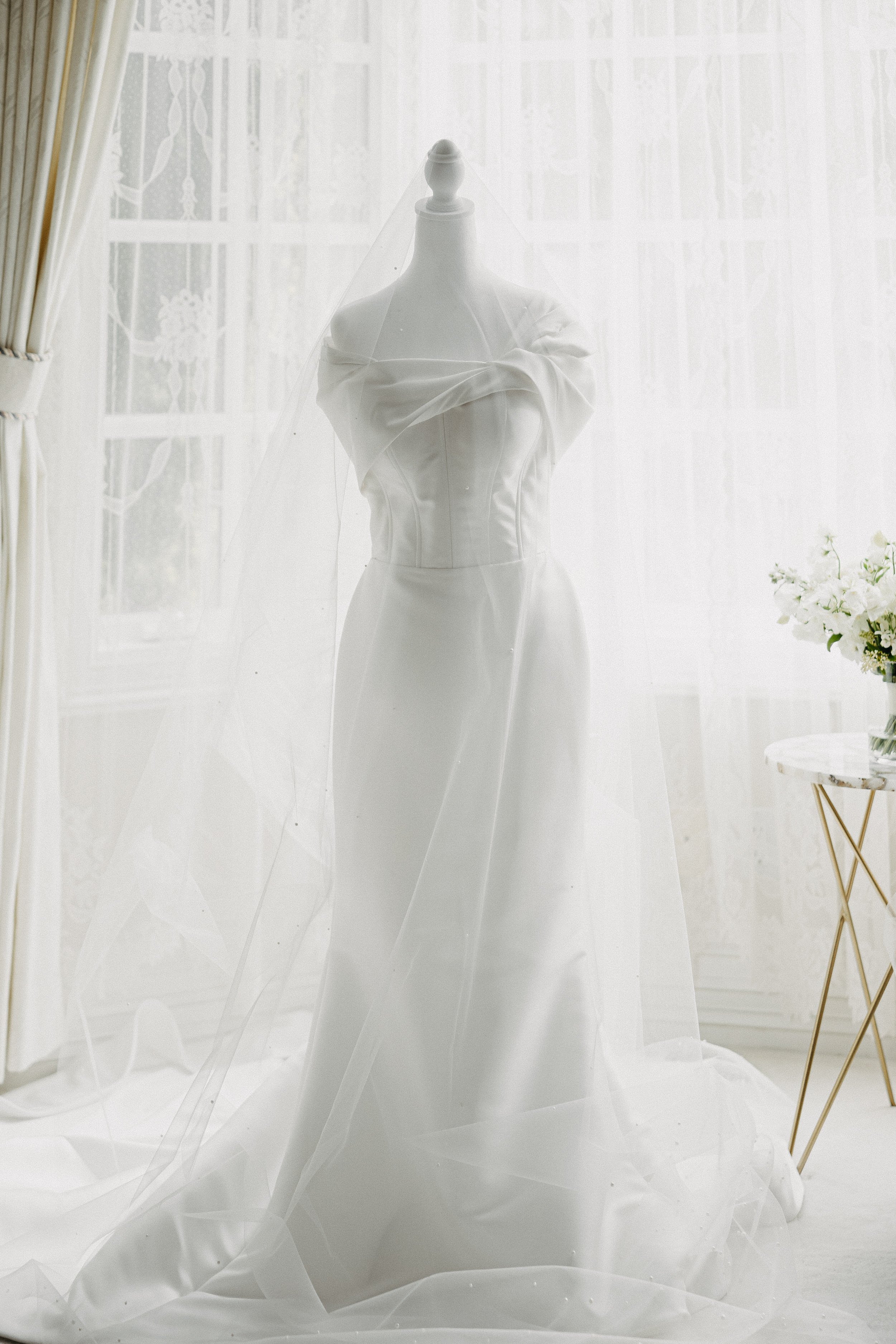 elegant wedding dress displayed on form in window