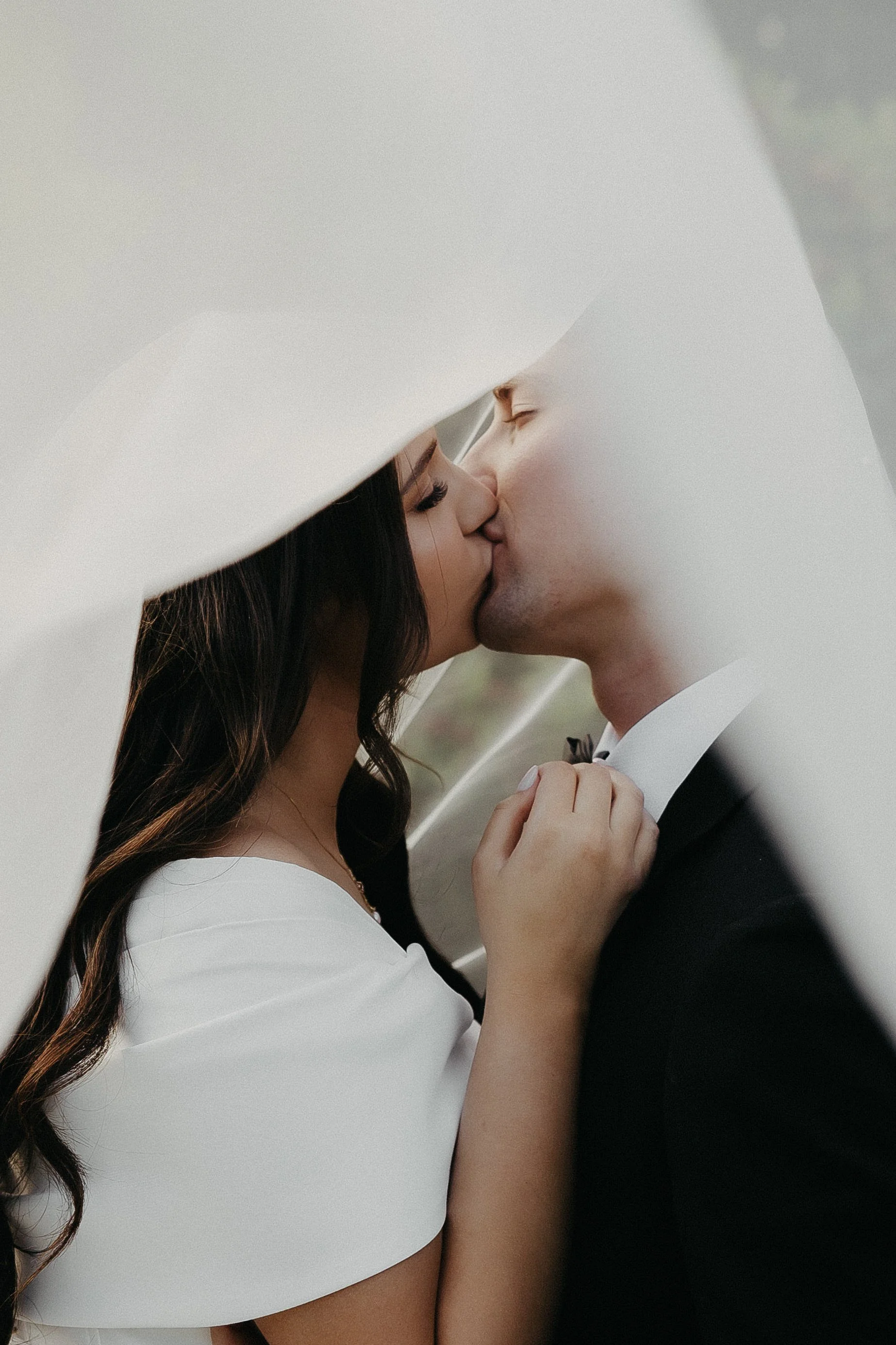 bride and groom kiss under veil sunset photos chateau de michellia